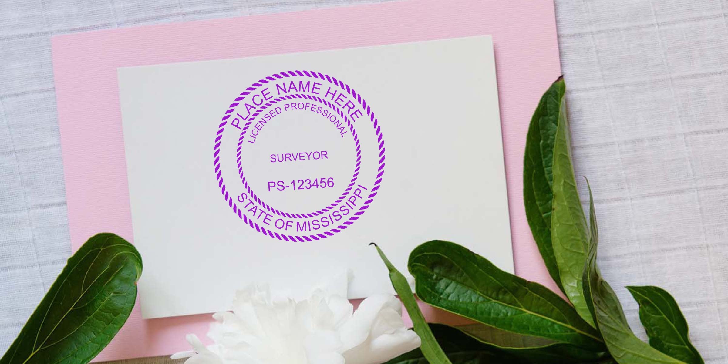 Mississippi land surveyor stamp on white card with green leaves and pink background, showing a licensed professional land surveyor emblem.