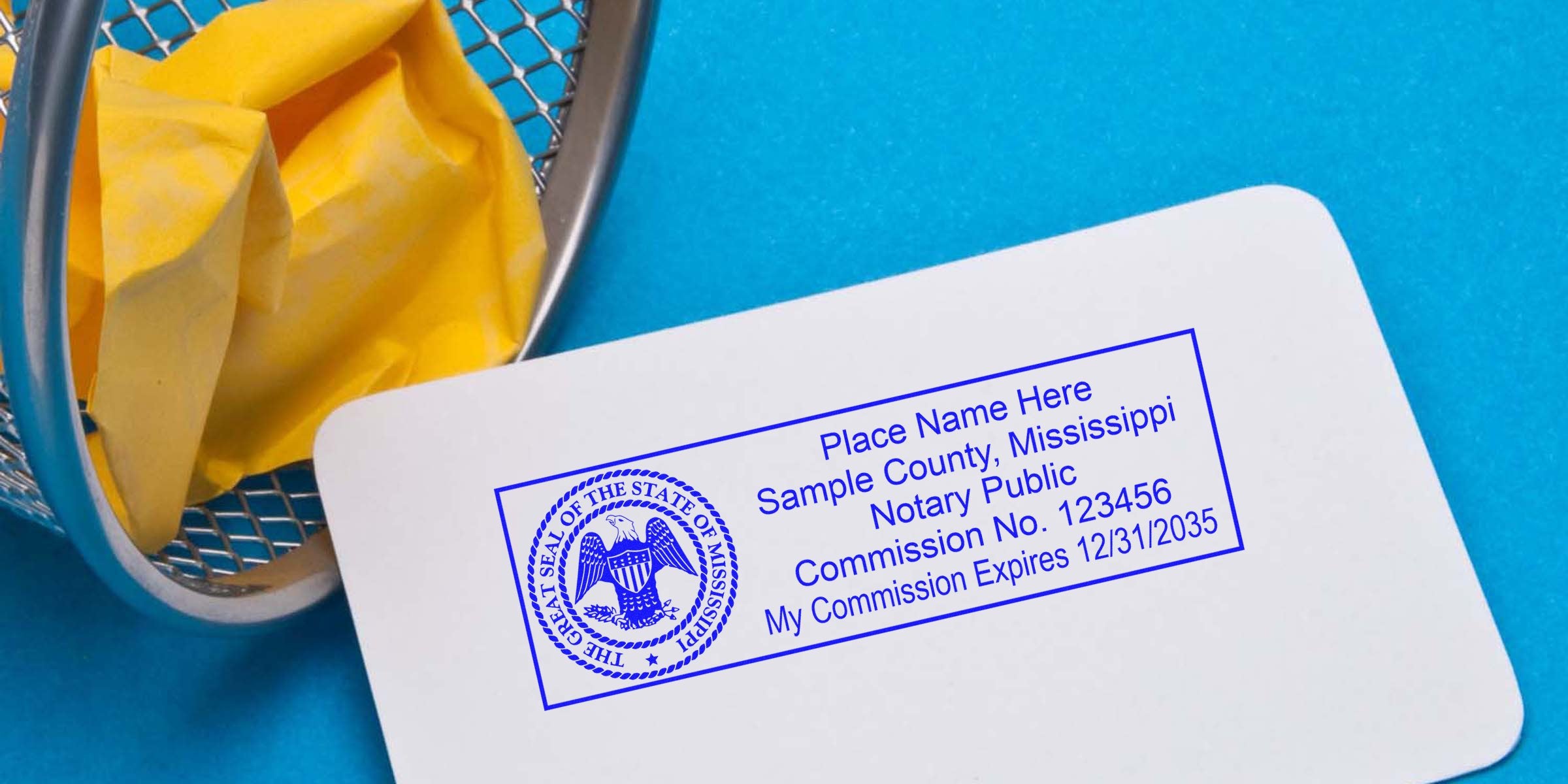 Mississippi notary public commission card with state seal and expiration date, on white card next to yellow crumpled paper in metal trash bin, blue background, highlighting notary seal expiration and renewal in Mississippi.