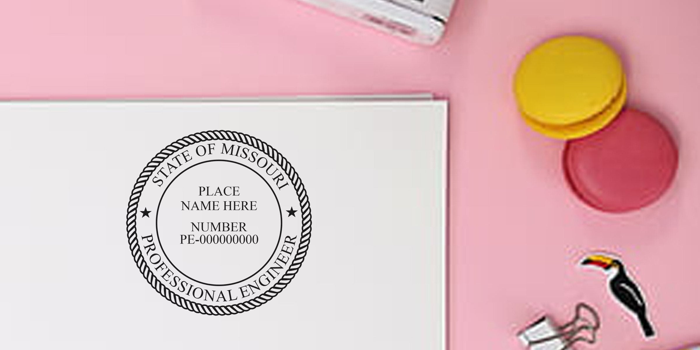 Missouri Engineer Seal custom stamp on white paper, surrounded by colorful macarons and office supplies on a pink background.