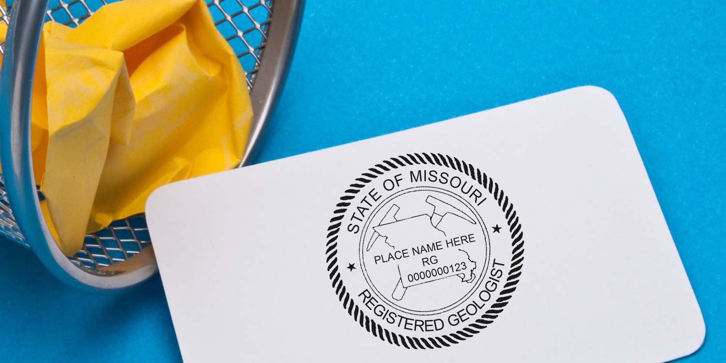 Missouri Licensed Geologist Seal on a certified geologist card next to a small trash bin with crumpled yellow paper on a blue background, highlighting Missouri Licensed Geologist Requirements.