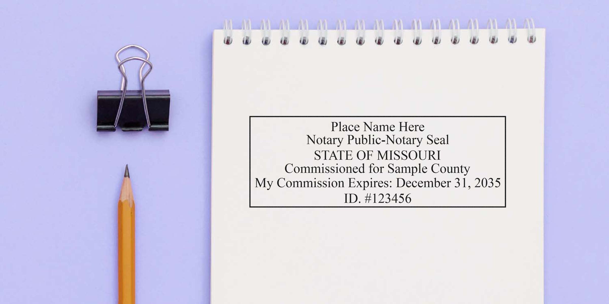 MO notary seal on spiral notebook with pencil and binder clip on purple background, highlighting tips for buying a Missouri notary seal.