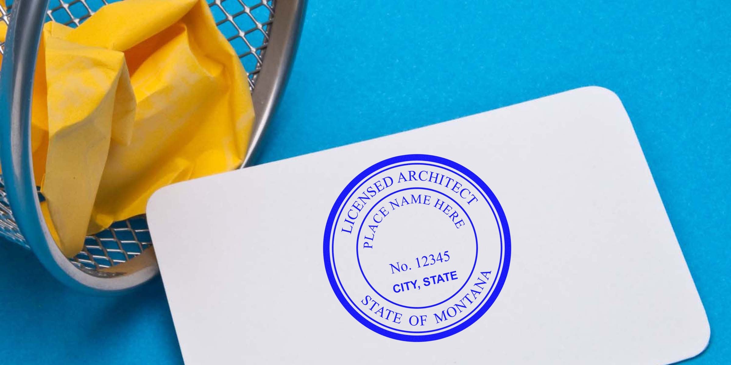 Montana architect stamp on white card against blue background, yellow crumpled paper in metal trash bin, symbolizing Montana architect licensing.