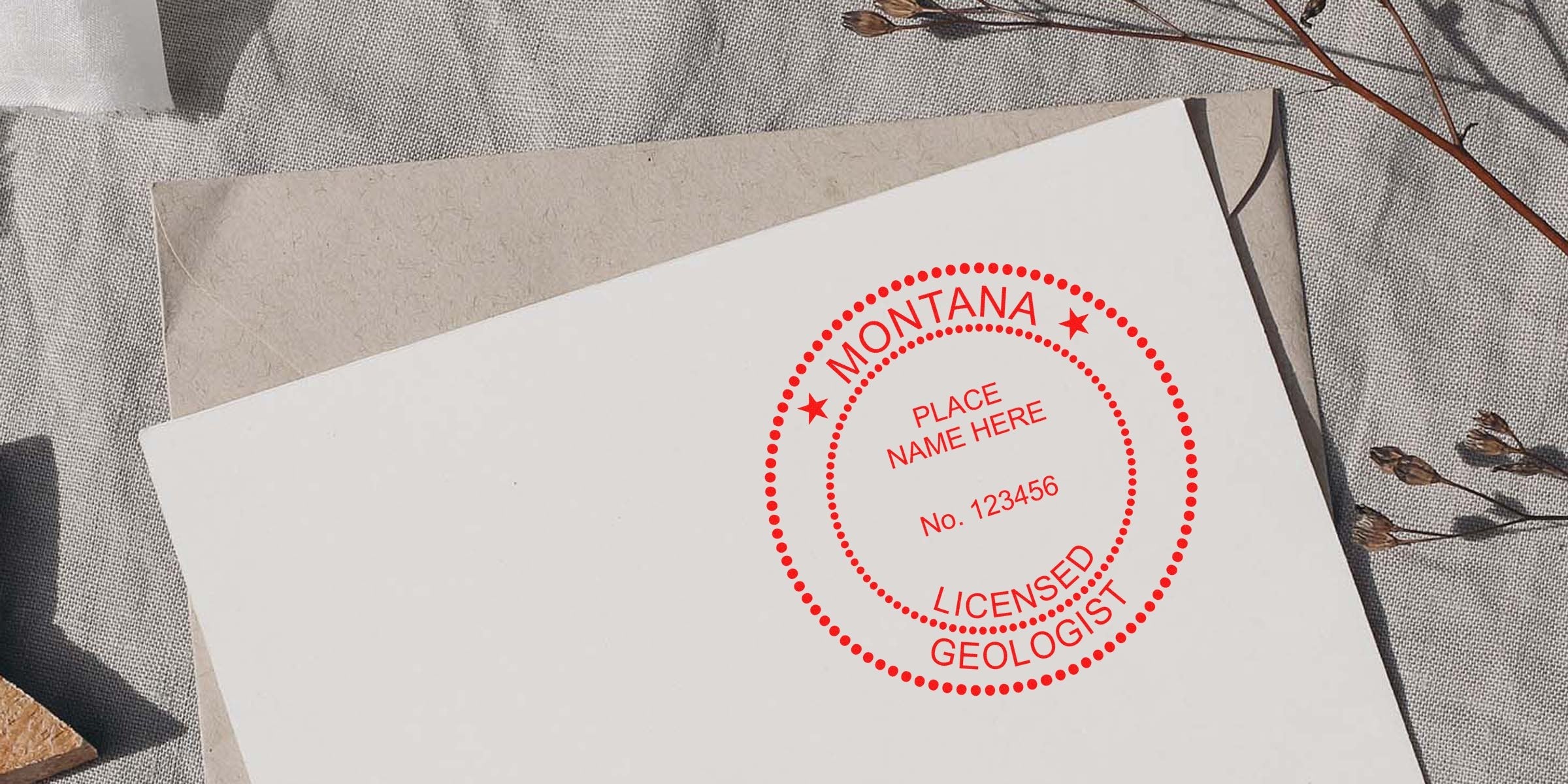 Vintage Montana licensed geologist stamp on white paper, with envelope and dried flowers background, a collectible geology stamp.