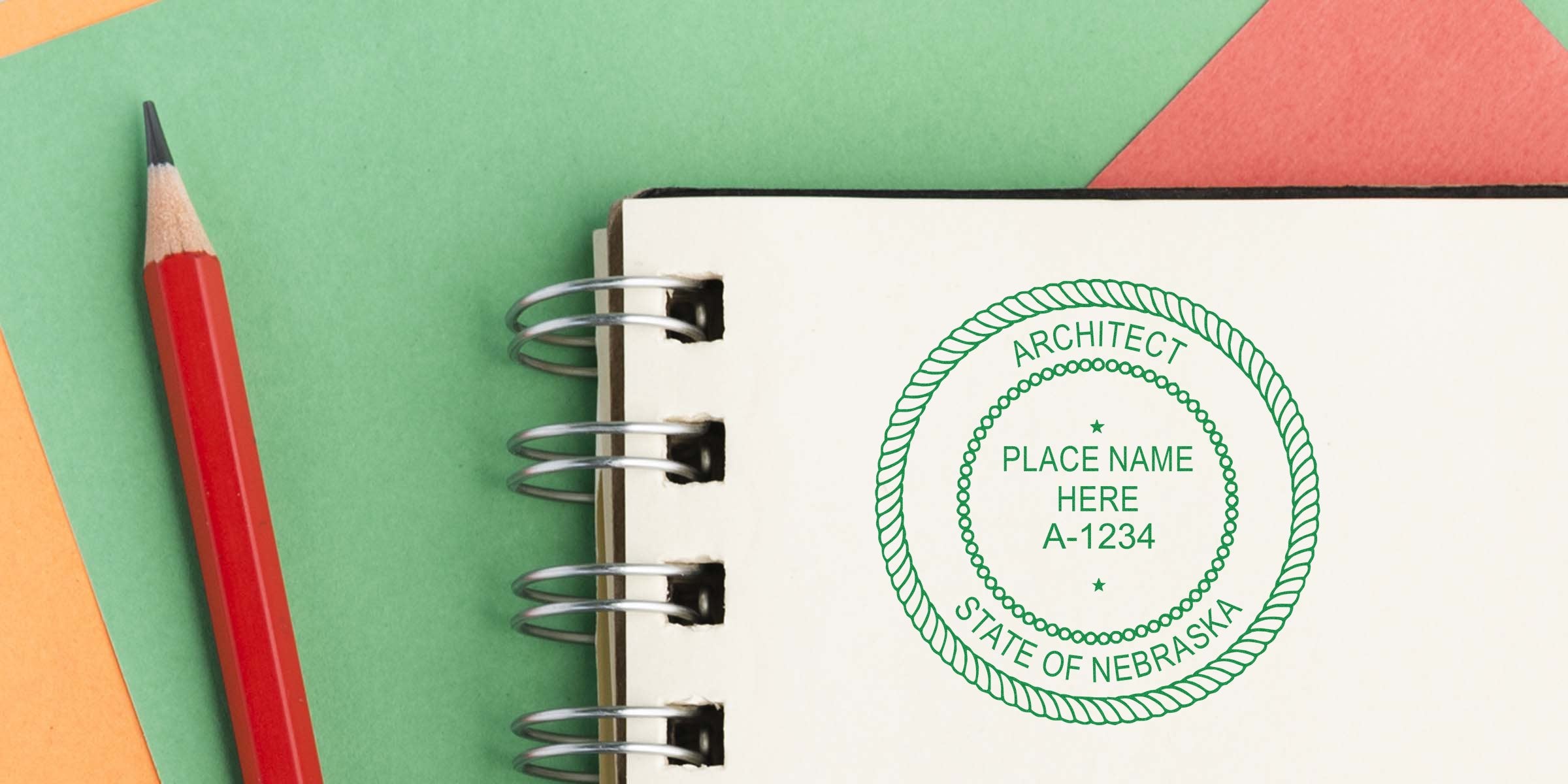 Custom Nebraska architect stamps with a seal design on a notebook and red pencil, displayed against a vibrant background.