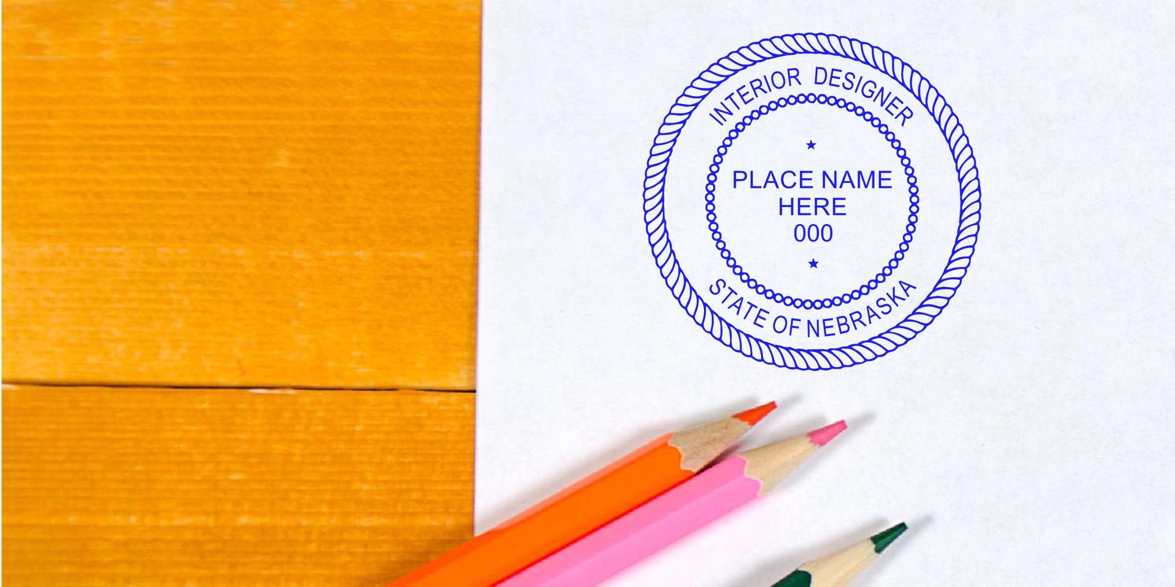 Interior Designer Stamp Nebraska on paper with colored pencils on wooden desk, showing Nebraska Interior Design Regulations certification seal.