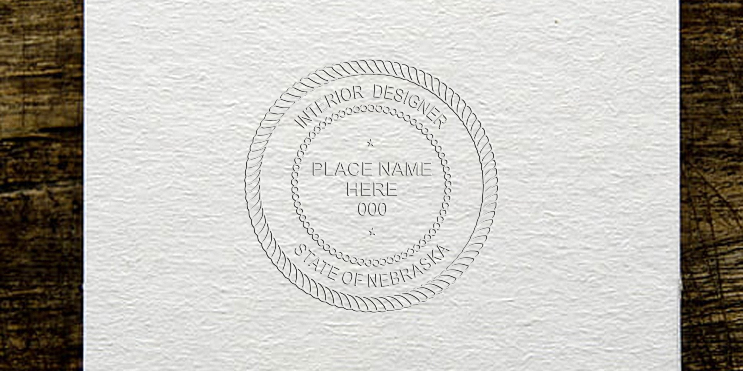 Nebraska interior designer's embossed seal on textured paper with wooden background, showcased in an online stamp guide.