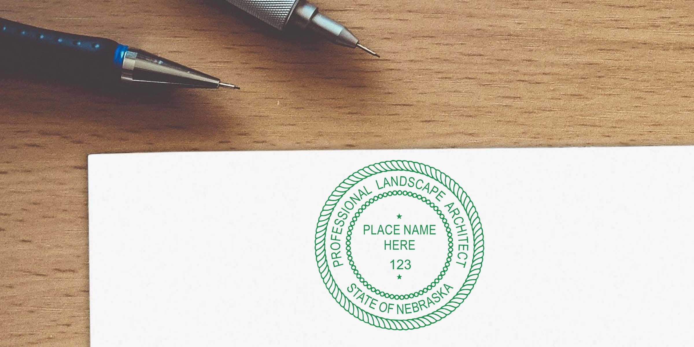 Nebraska landscape architect stamp on white paper with pens on wooden desk, symbolizing Nebraska landscape architect licensing.