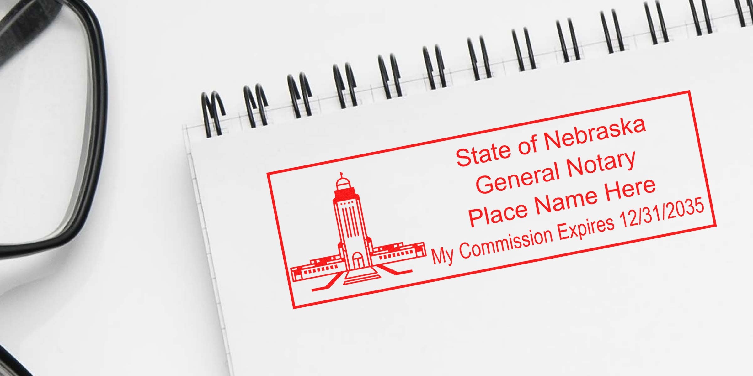 Nebraska general notary stamp on notebook with glasses, showing commission expiration date; perfect for buying or ordering a notary stamp online.
