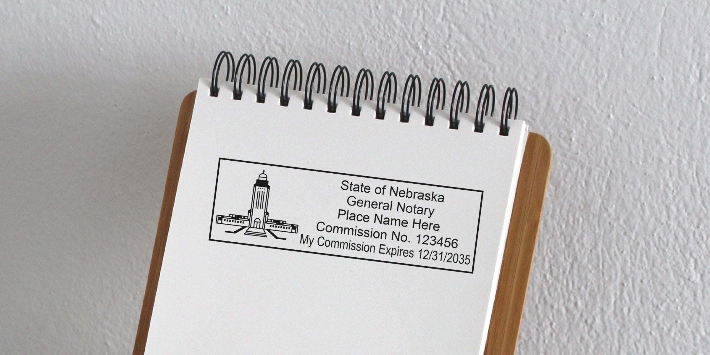 Nebraska notary stamp on a spiral notebook shows commission details and expiration date, providing tips for those wanting to become a Nebraska notary.