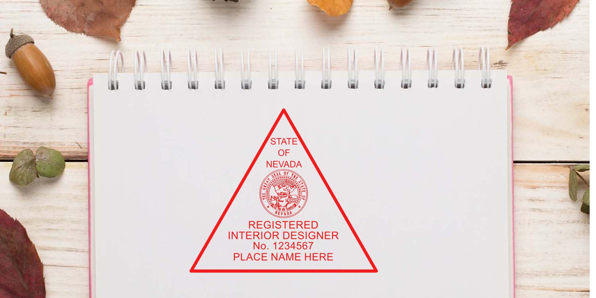 Nevada interior designer stamp on notebook with autumn leaves and acorns, highlighting certification and compliance for professional registration.