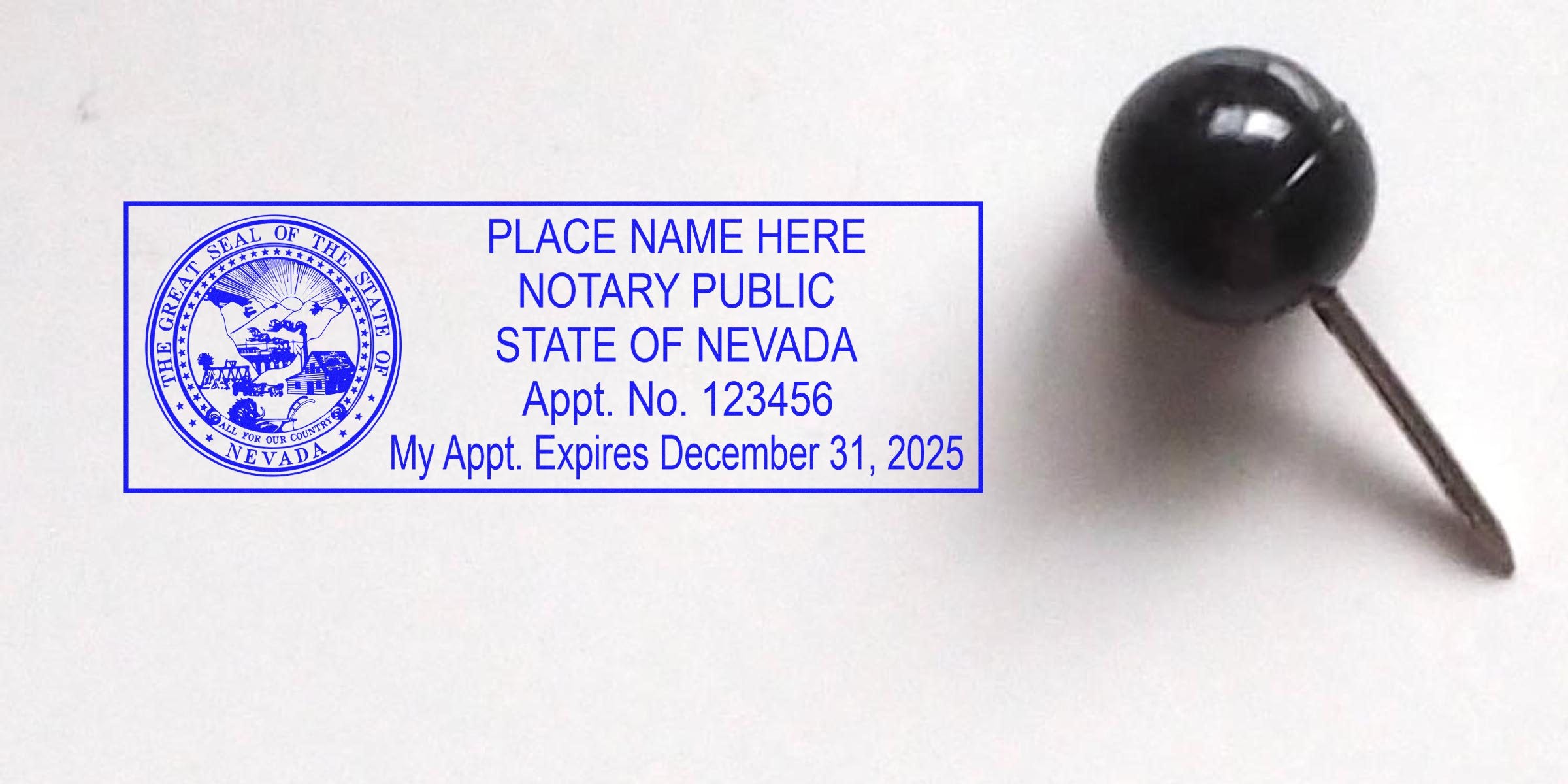 Nevada notary stamp with official seal and appointment expiration date next to a black push pin on a white background.