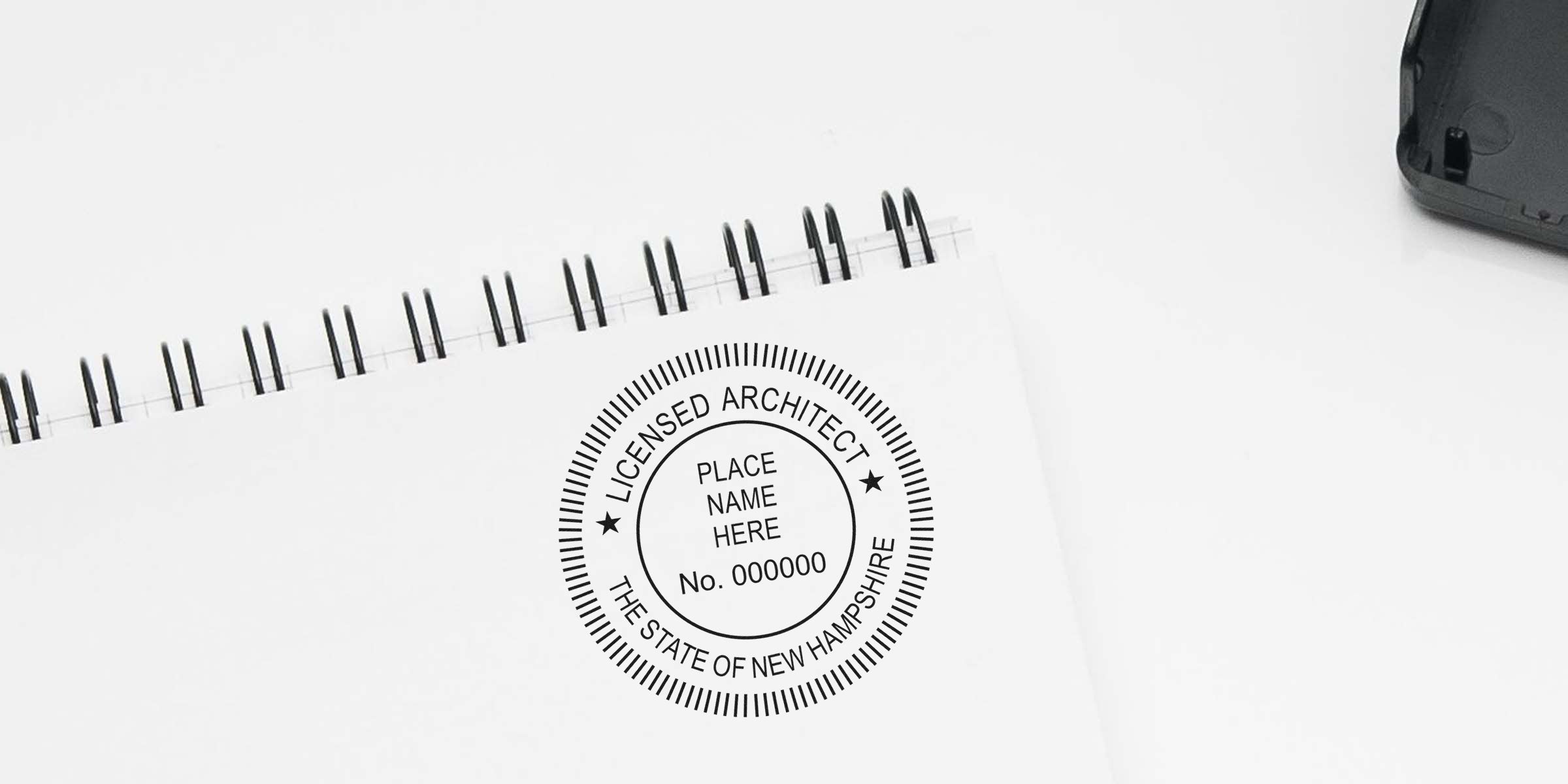 New Hampshire architect seal stamped on spiral notebook for license verification.