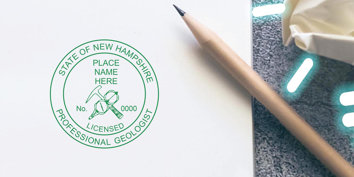 Geologist stamp for New Hampshire on desk with pencil and crumpled paper, symbolizing New Hampshire Geologist Licensing.