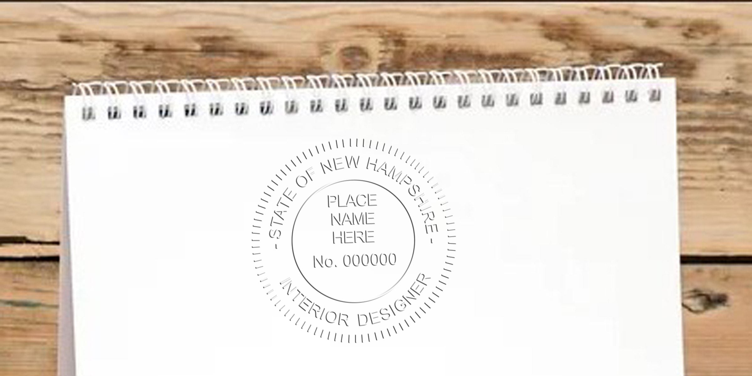 New Hampshire interior designer stamp on white spiral notebook on wooden table, highlighting online interior designer stamp.
