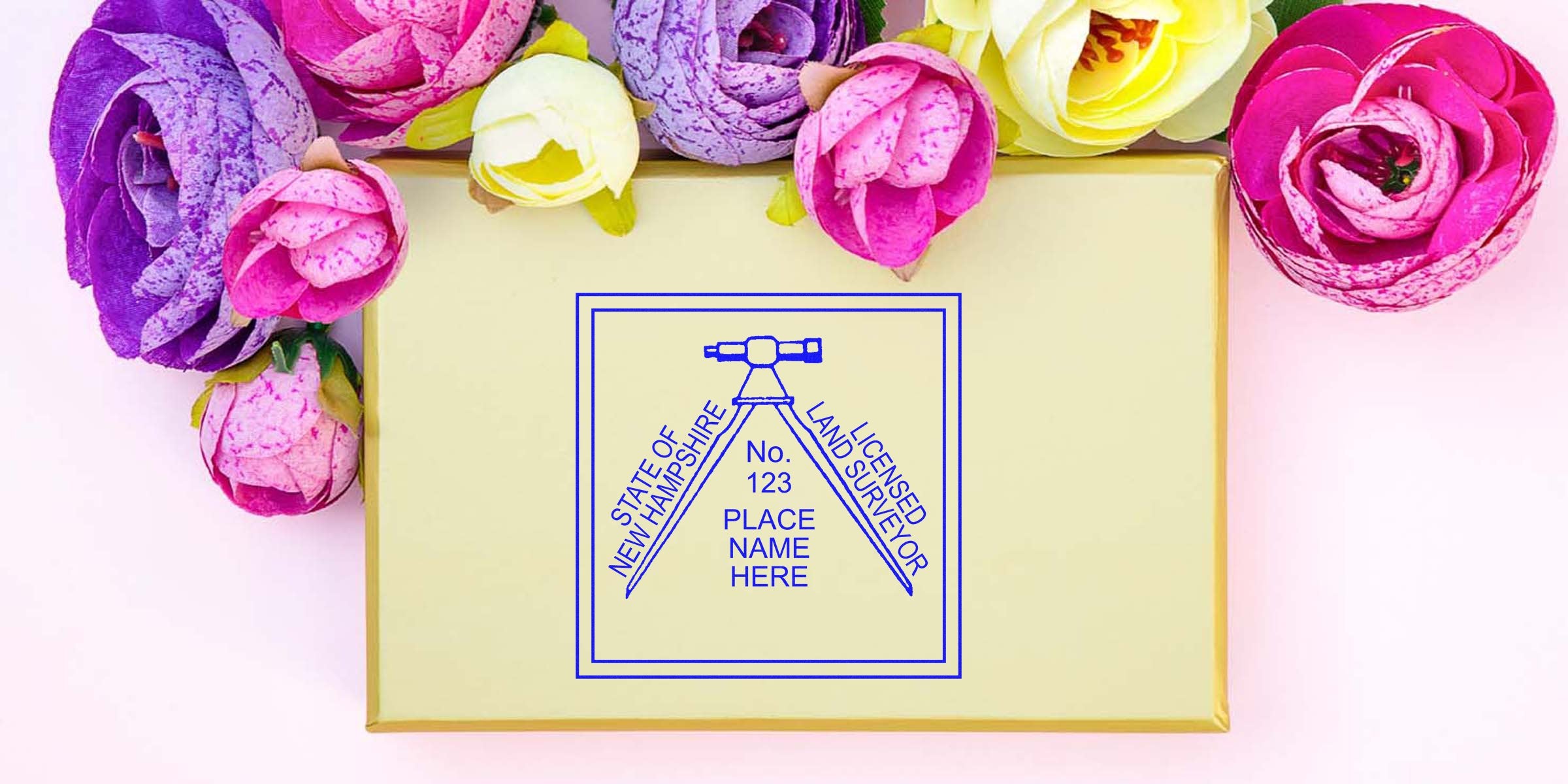 New Hampshire land surveyor stamp on beige background, framed by vibrant artificial flowers.