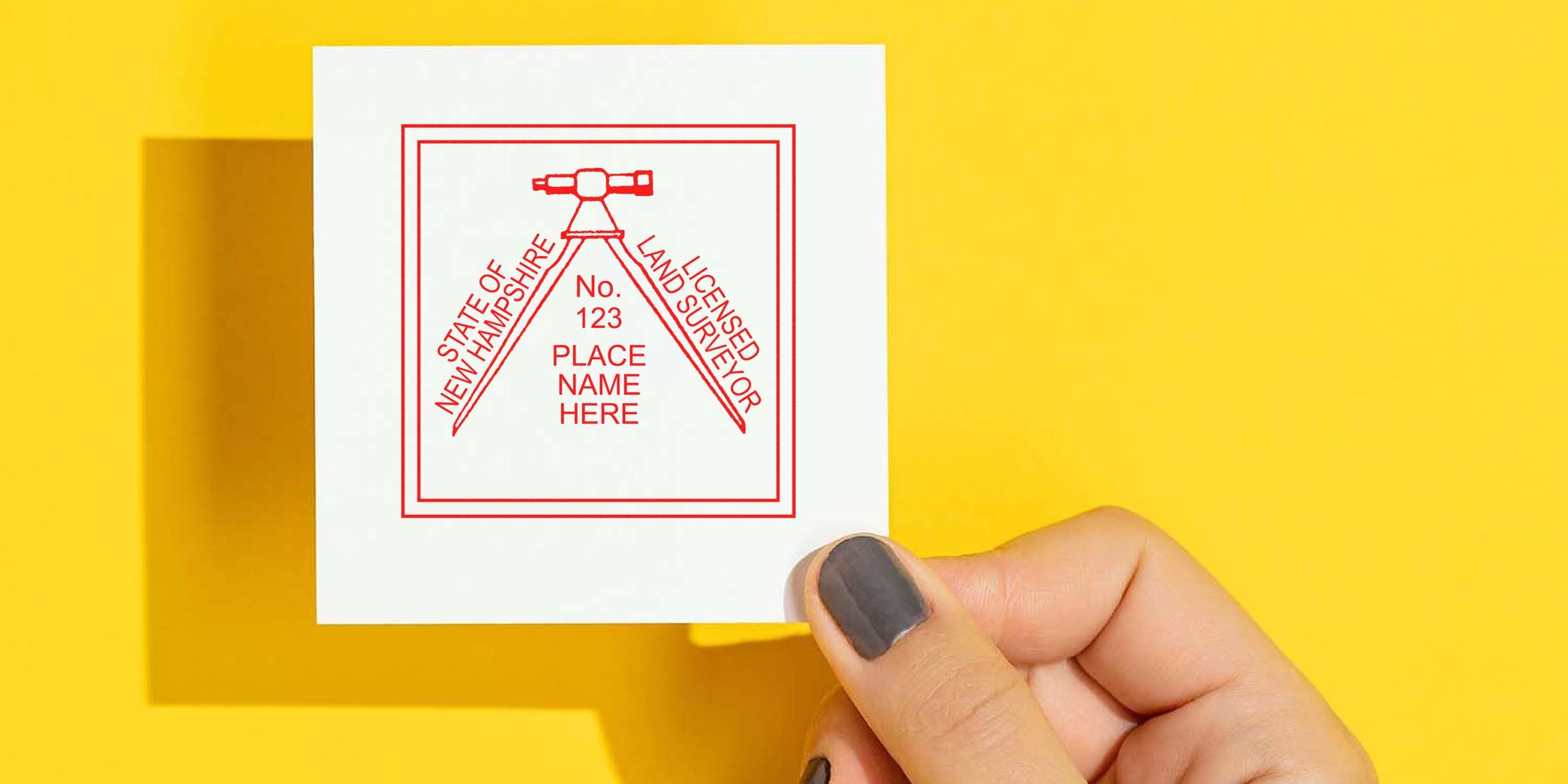 Hand holding a New Hampshire land surveyor stamp for property survey certification with customizable surveyor stamp.
