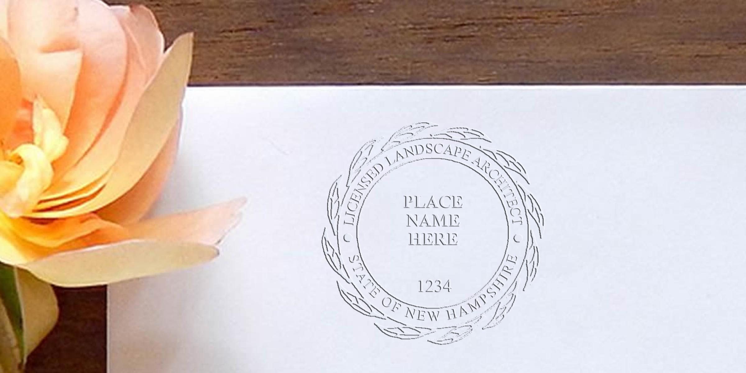 Embossed New Hampshire landscape architect stamp on white paper with peach flower on wooden table, showing licensed architect seal and stamp issuance rules.