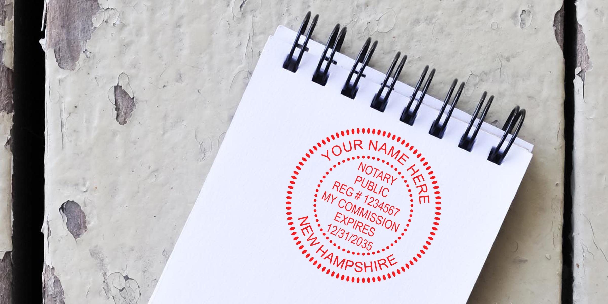New Hampshire notary stamp on white spiral notebook displaying commission expiration date, featured in notary public guide.