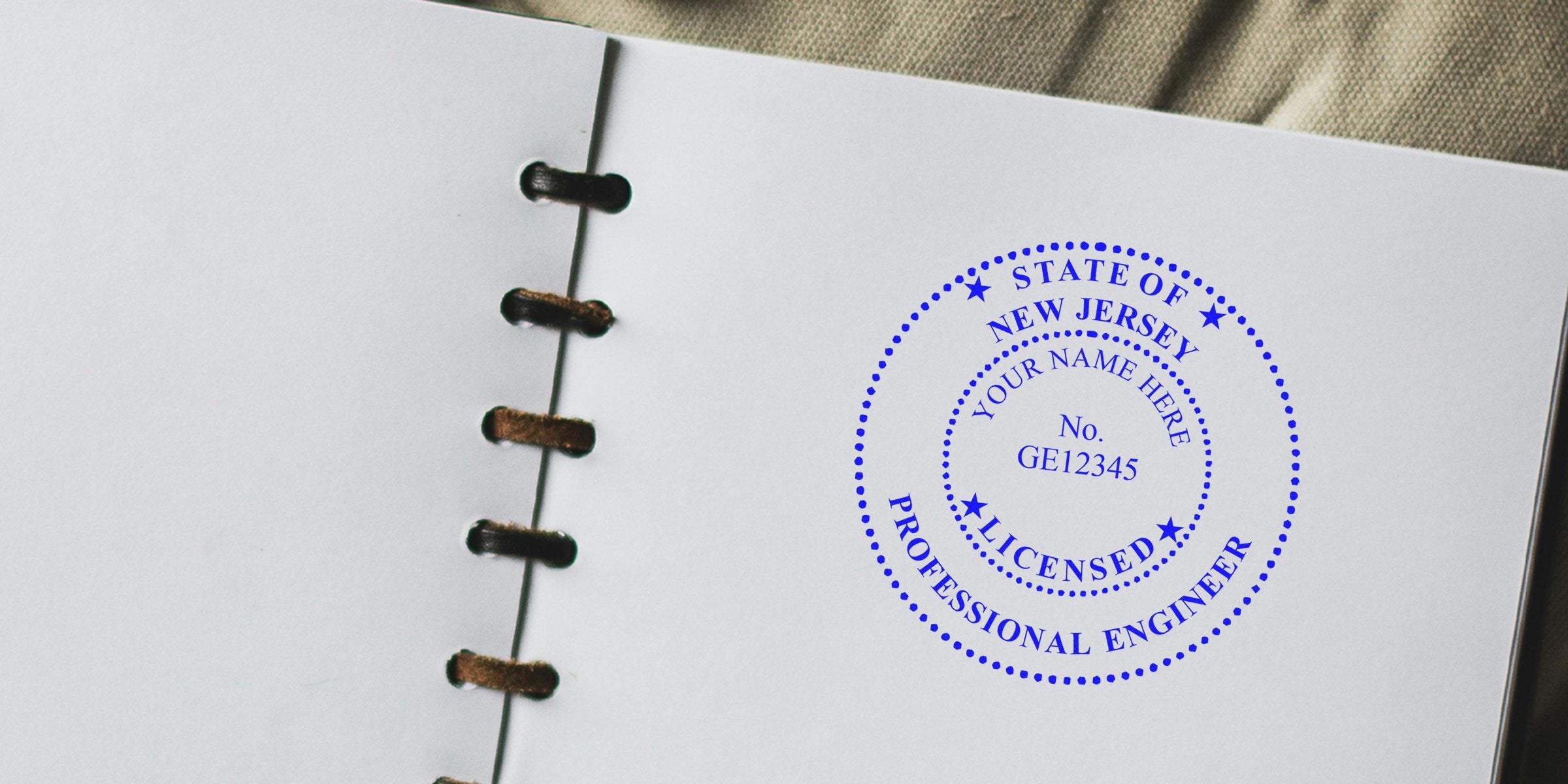 New Jersey PE stamp embosser and engineer embossing tool imprint on white notebook page.