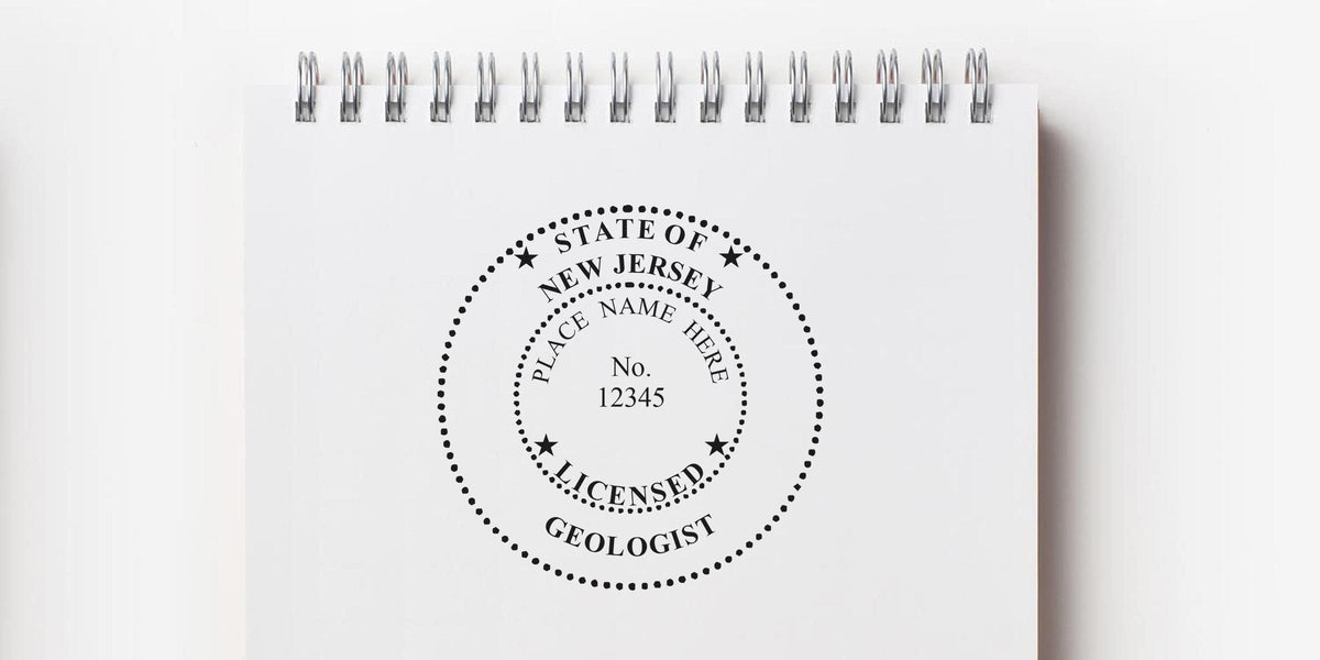 New Jersey licensed geologist stamp on white spiral notebook, part of the professional geologist stamp guide.