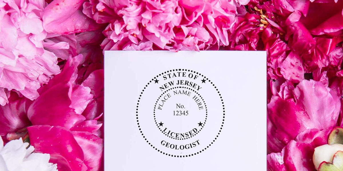 New Jersey licensed geologist stamp on white paper, surrounded by pink and white flowers, highlighting NJ geologist stamp and online geologist certification.