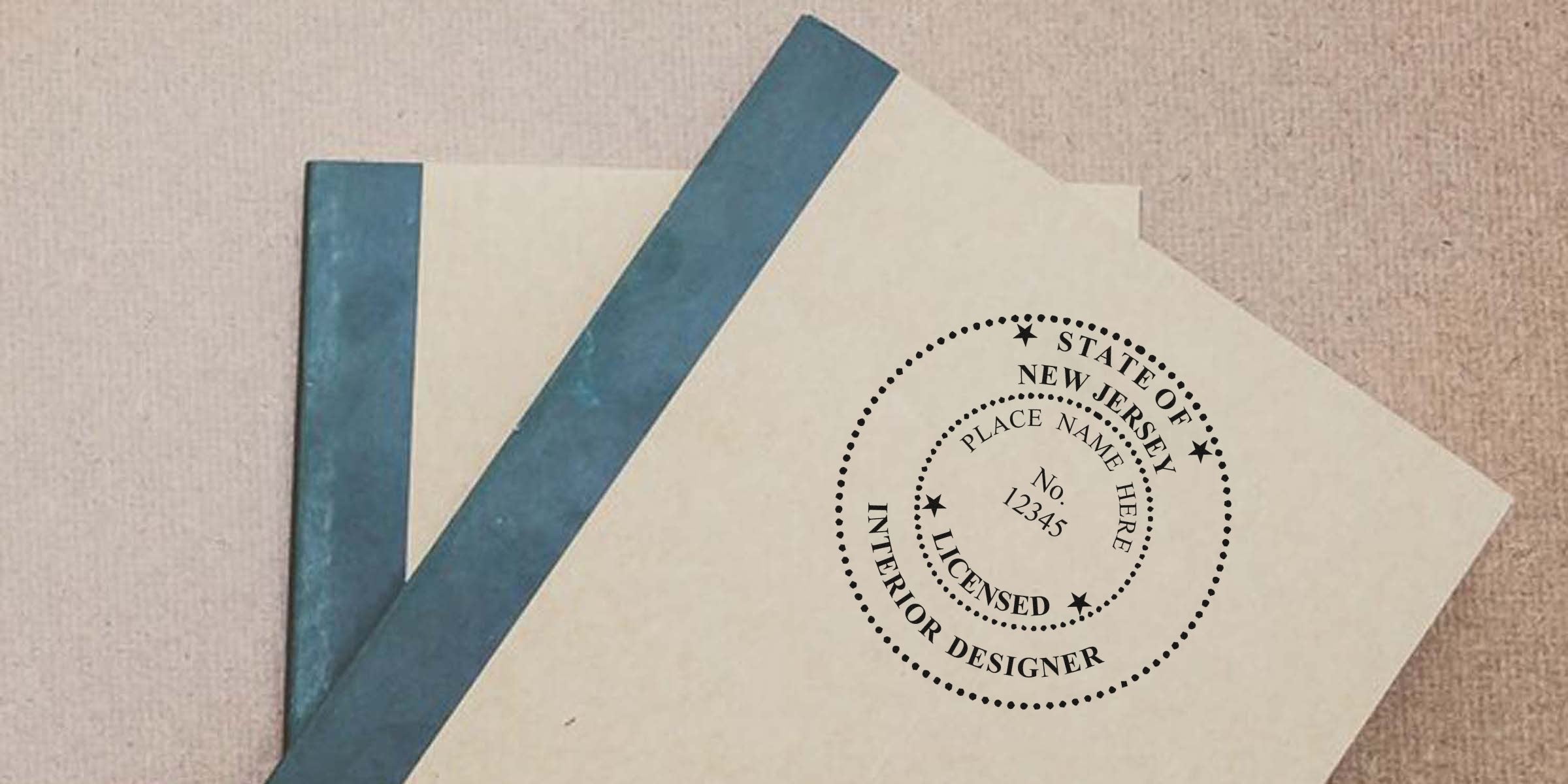 New Jersey interior designer stamp on beige folders with blue spines, displaying NJ interior design licensing certification.