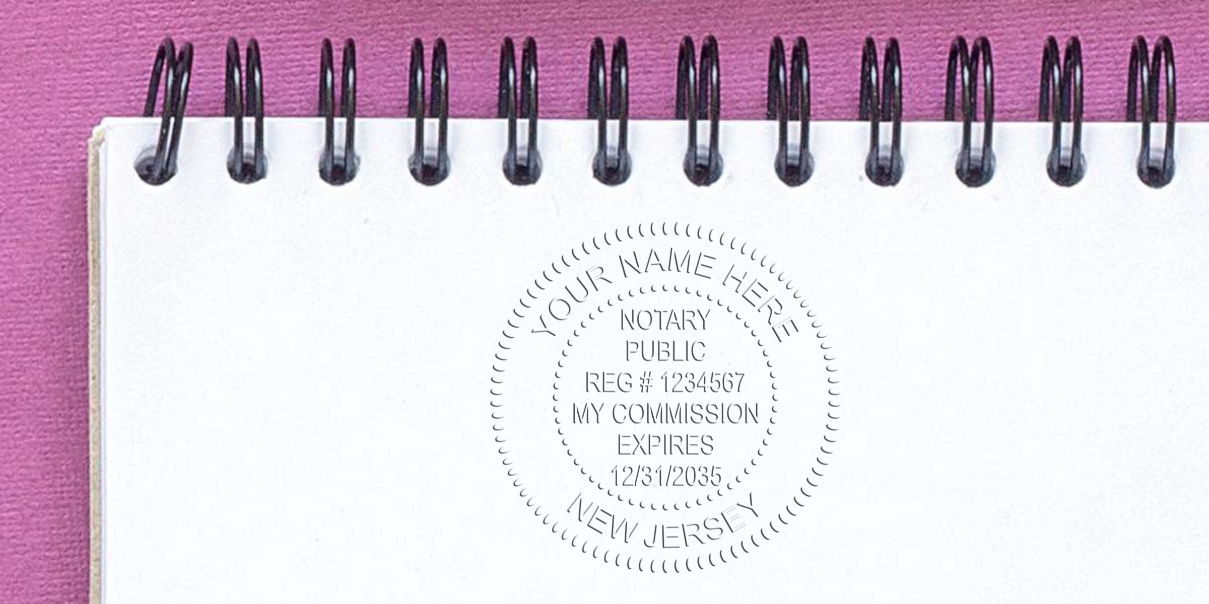 New Jersey notary stamp on white spiral notebook with pink background, showing NJ notary commission seal and official stamp format examples.