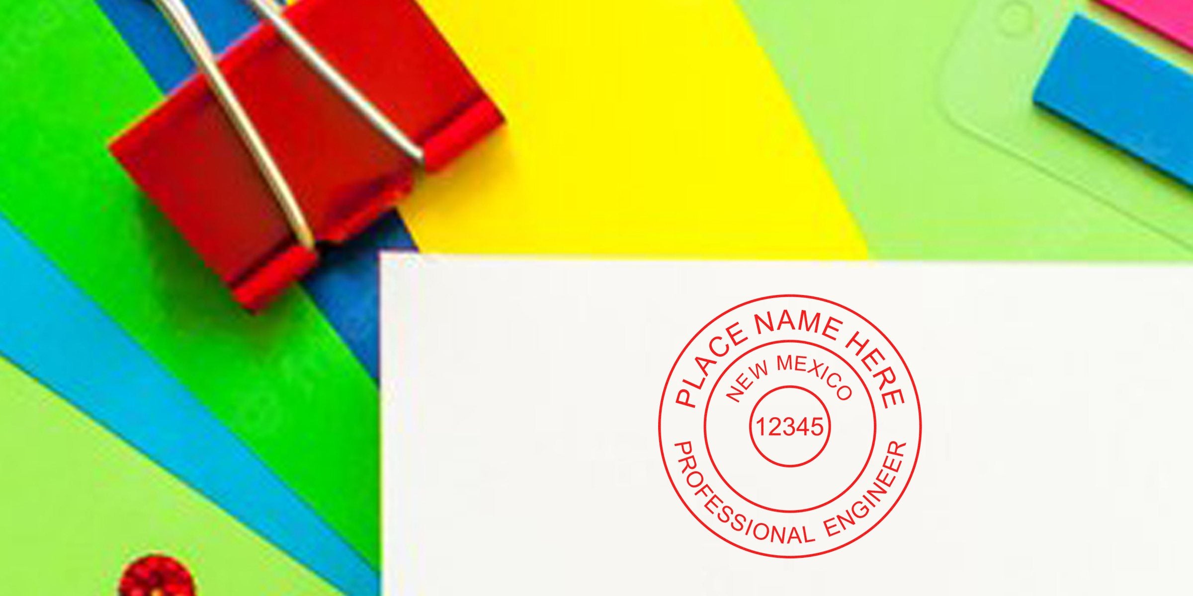 Red binder clip holds white paper with New Mexico engineer seal against colorful background, highlighting engineer seal design tips.