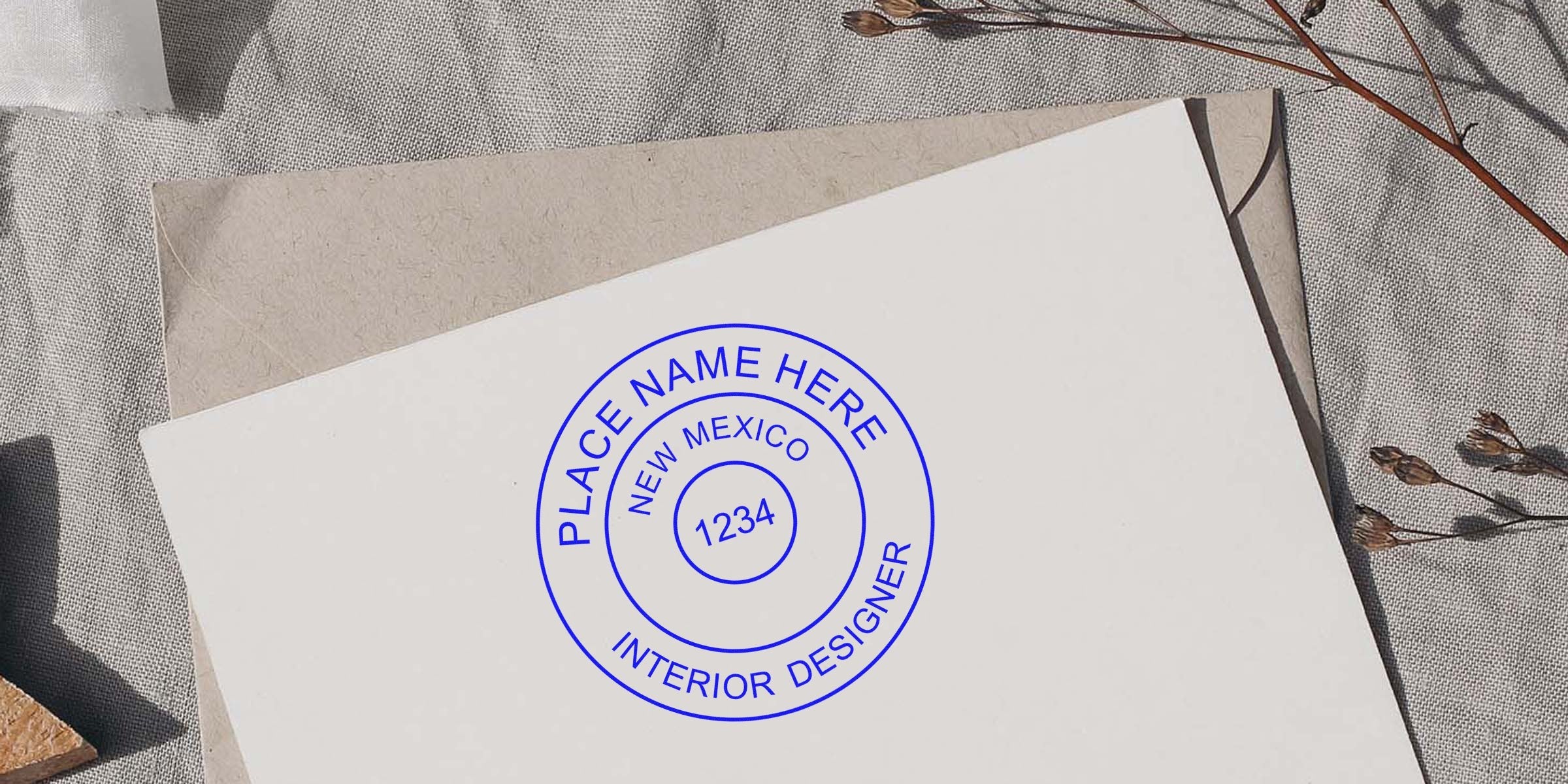 Custom New Mexico interior designer stamp on white paper, surrounded by dried flowers and textured fabric, highlighting common mistakes when buying interior designer stamps.
