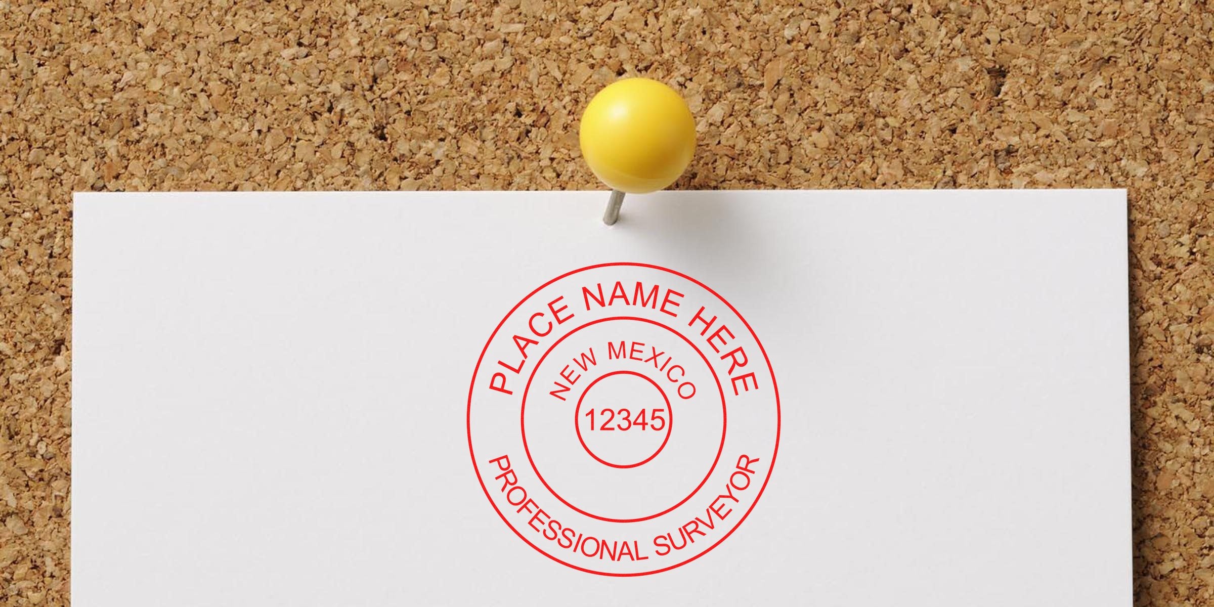 Custom New Mexico land surveyor stamp pinned on corkboard with a yellow pushpin, ideal for ordering a land surveyor stamp.