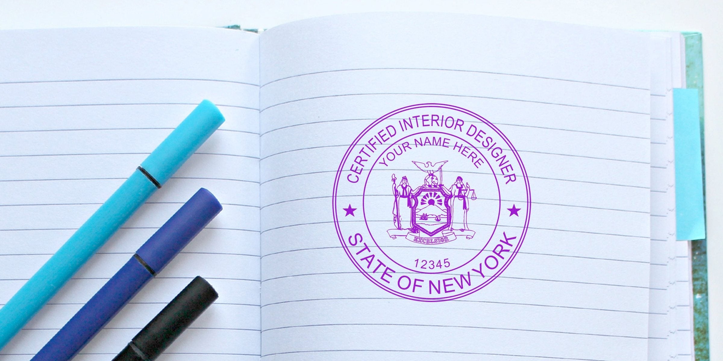 New York interior designer certification seal embossed on a notebook page, surrounded by colorful markers and a stamp embosser.