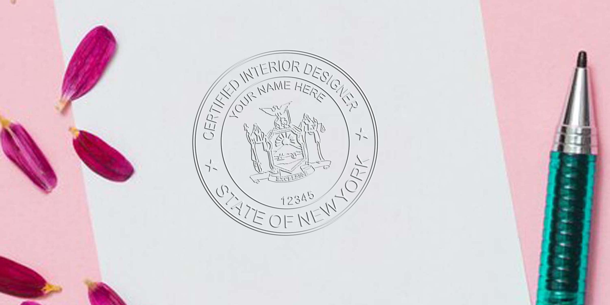 New York interior designer’s embossed stamp on white paper, surrounded by pink petals and a green pen, on a pink background, highlighting NY interior design certification.