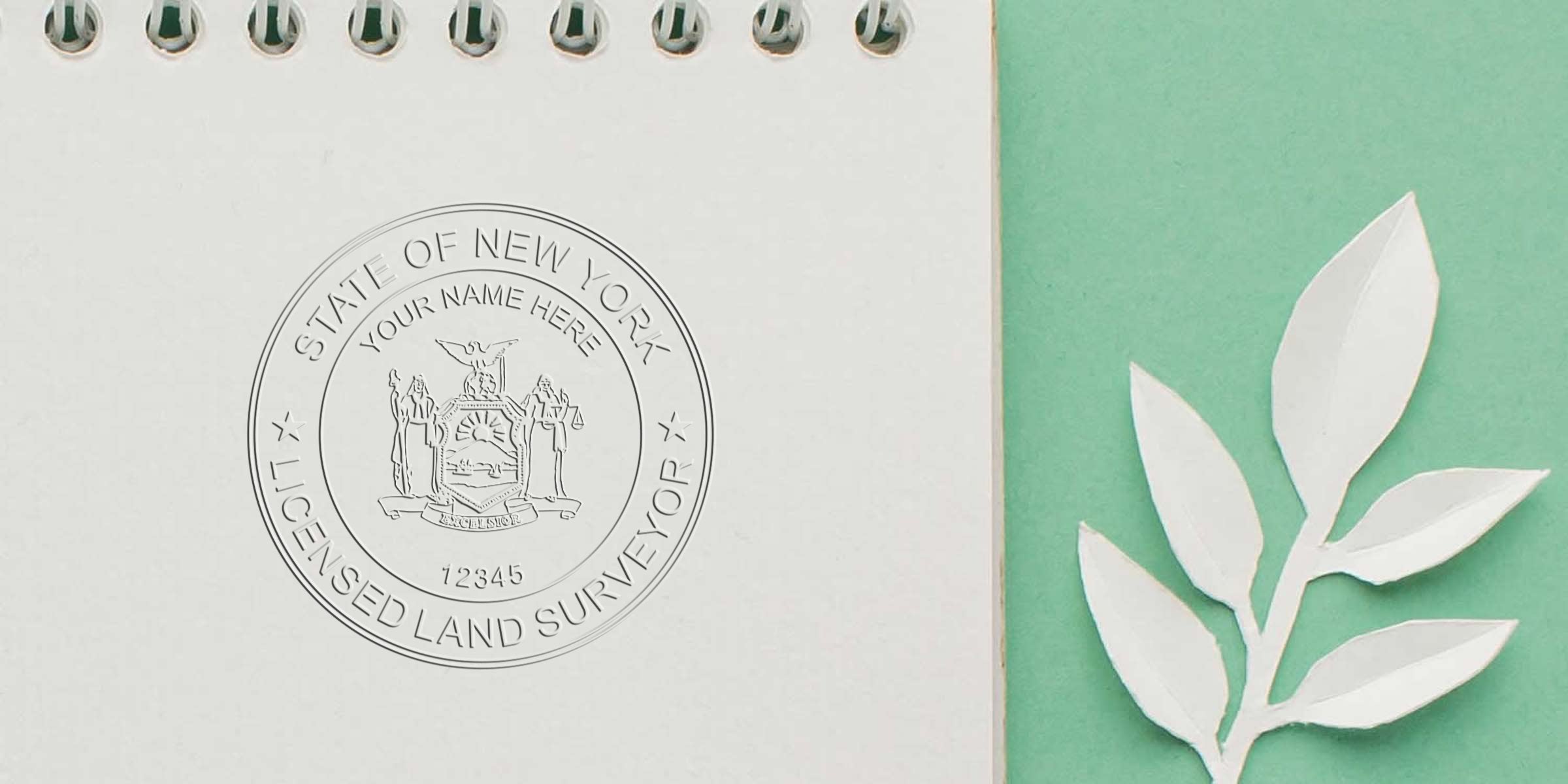 New York land surveyor’s embossed stamp on a notebook, symbolizing professional surveyor standards, with paper leaves on a green background.