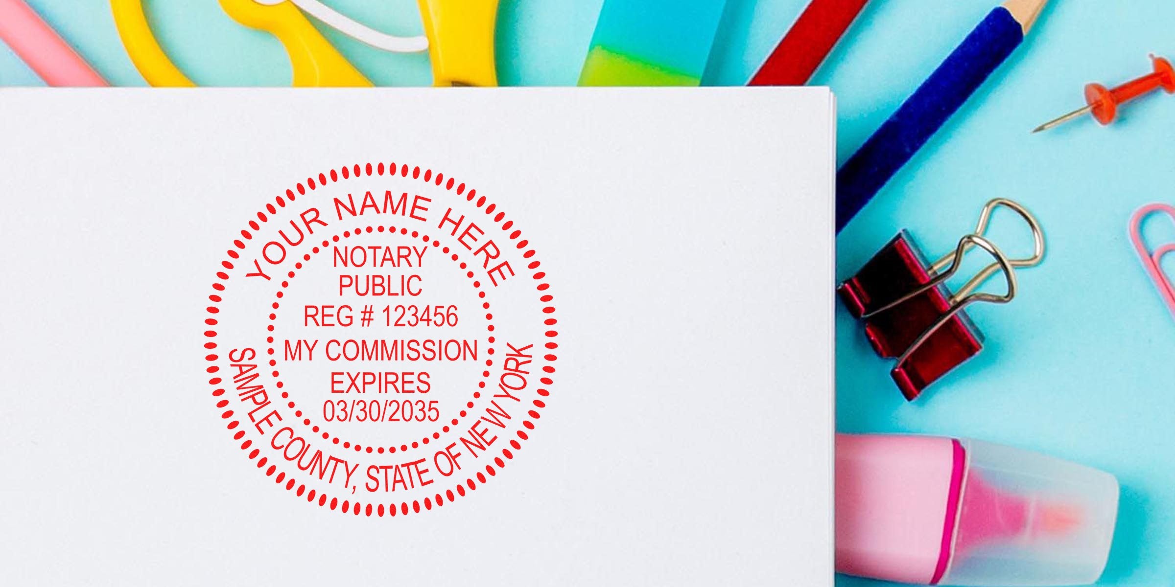 New York notary stamp on white paper with scissors, eraser, paper clips, and push pin on blue background, meeting official notary standards.