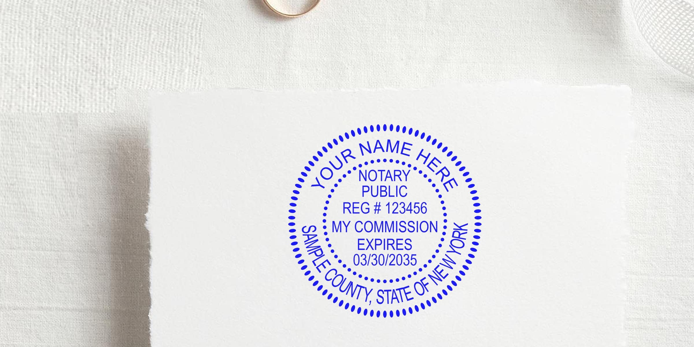 Custom New York notary stamp on white paper, personalized notary public seal, official commission stamp, essential notary supplies, and must-have New York notary essentials.