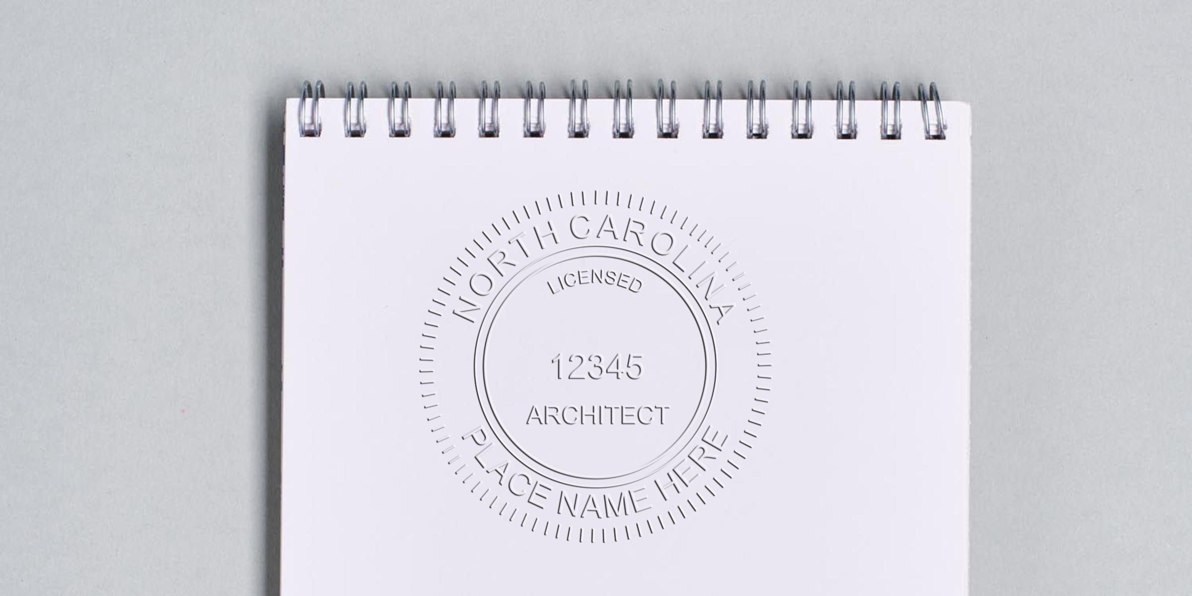 White spiral notebook embossed with North Carolina architect seal, meeting professional certification requirements.