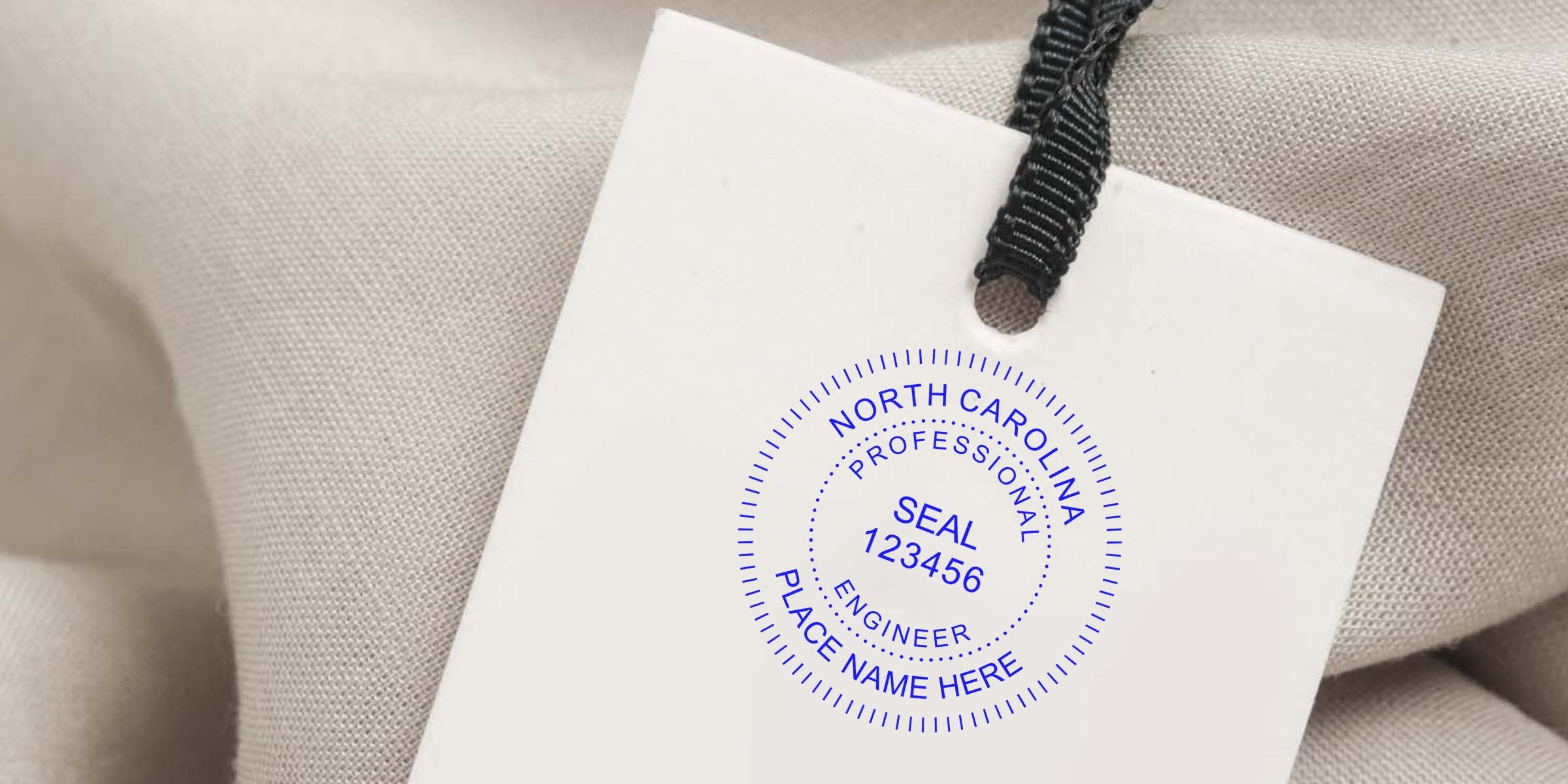 North Carolina engineering seal on white tag with black string, set against beige fabric, following the engineering seal design guide.