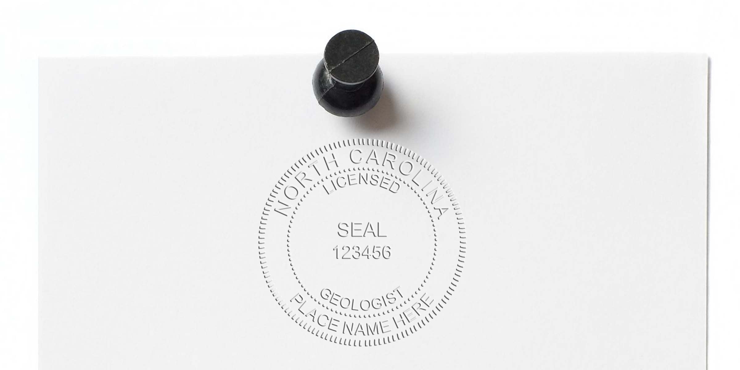 North Carolina Geologist Seal embossed on white paper, pinned with a black thumbtack, displaying the Geologist Seal design.