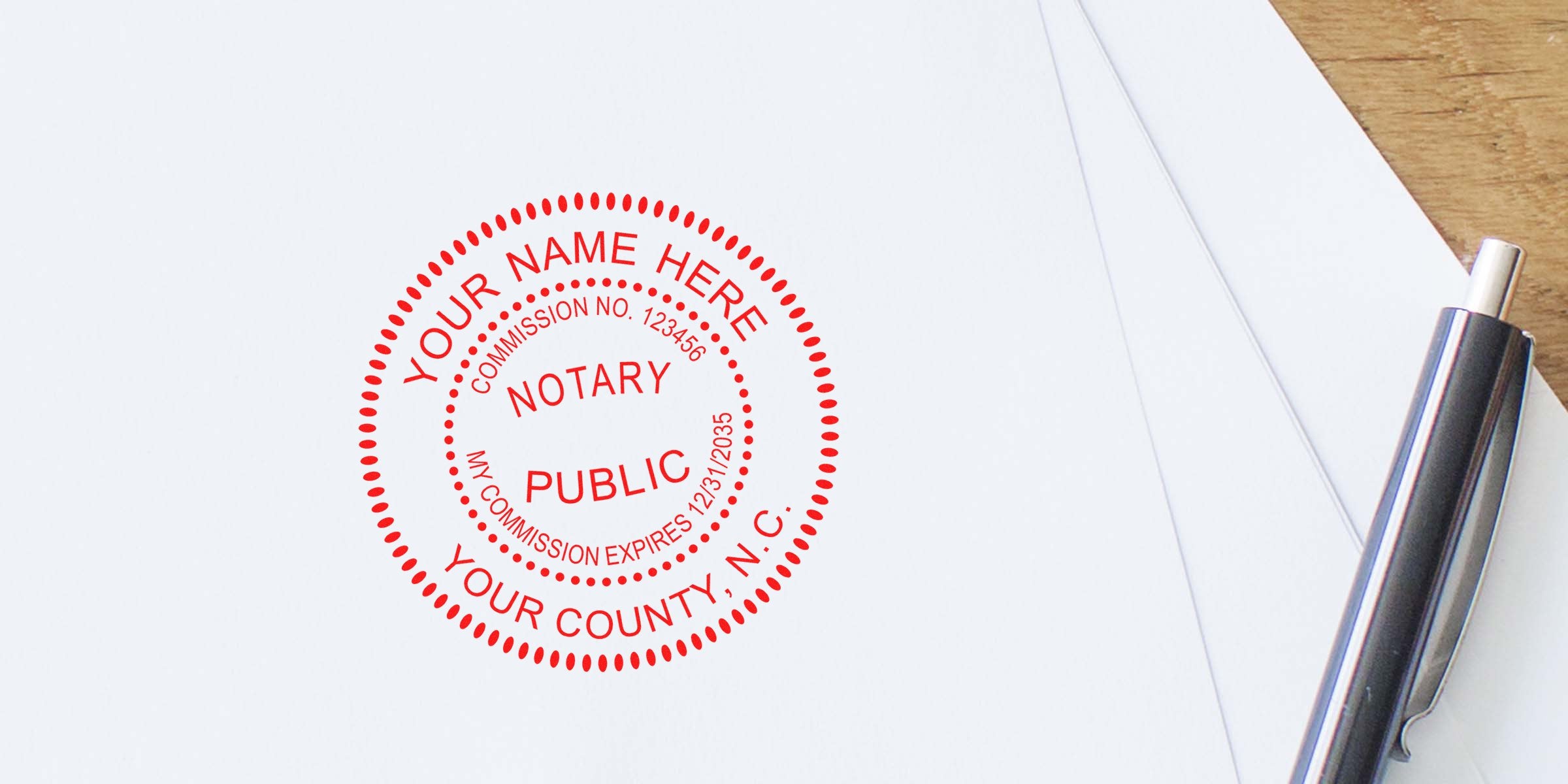 Notary public stamp on white paper with pen, official North Carolina notary seal, essential NC notary supplies and tools for legal documents.