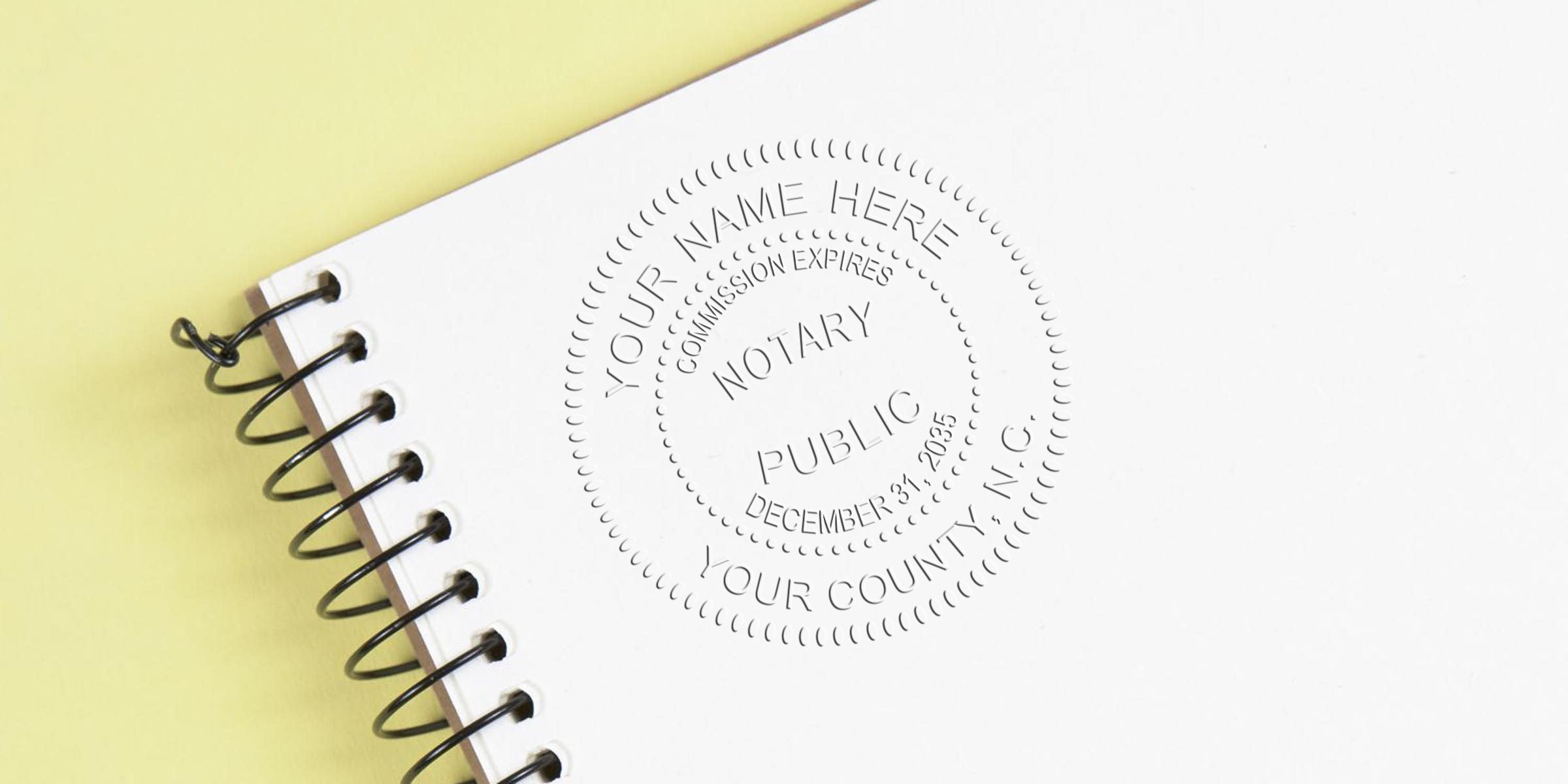 North Carolina Notary Seal stamp on white spiral notebook for legal document verification, featuring official NC Notary Supplies.