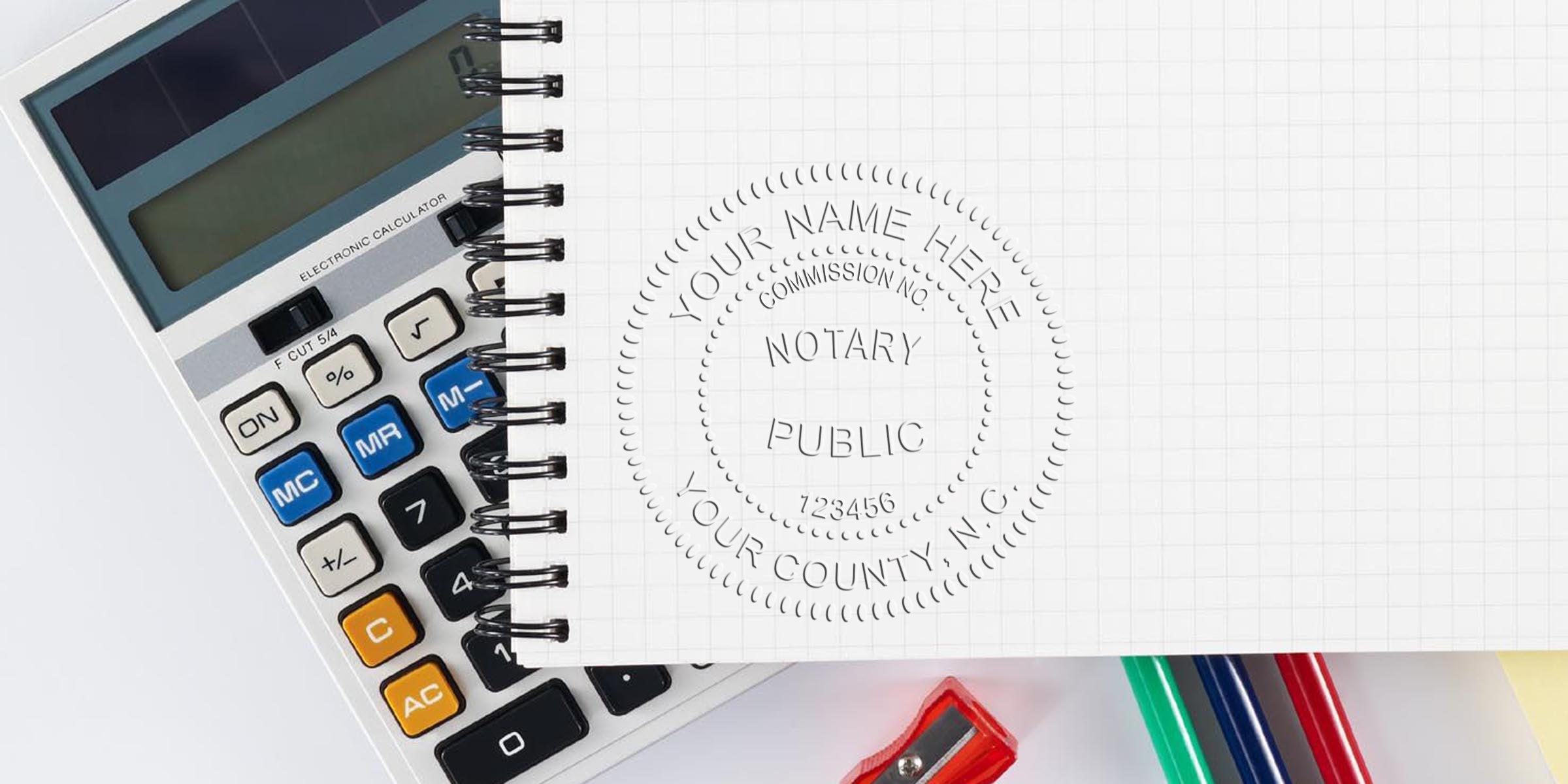 North Carolina notary stamp on notebook with calculator and office supplies, symbolizing notary services, document verification, and online notary stamp options in North Carolina.
