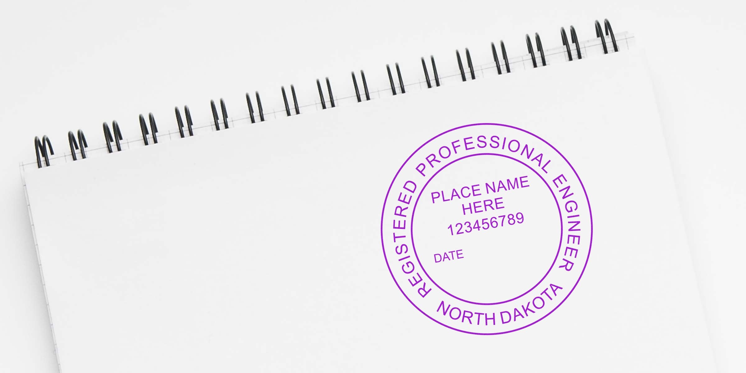 North Dakota professional engineer stamp on white spiral notebook, showing ND engineering stamp laws and seal requirements.