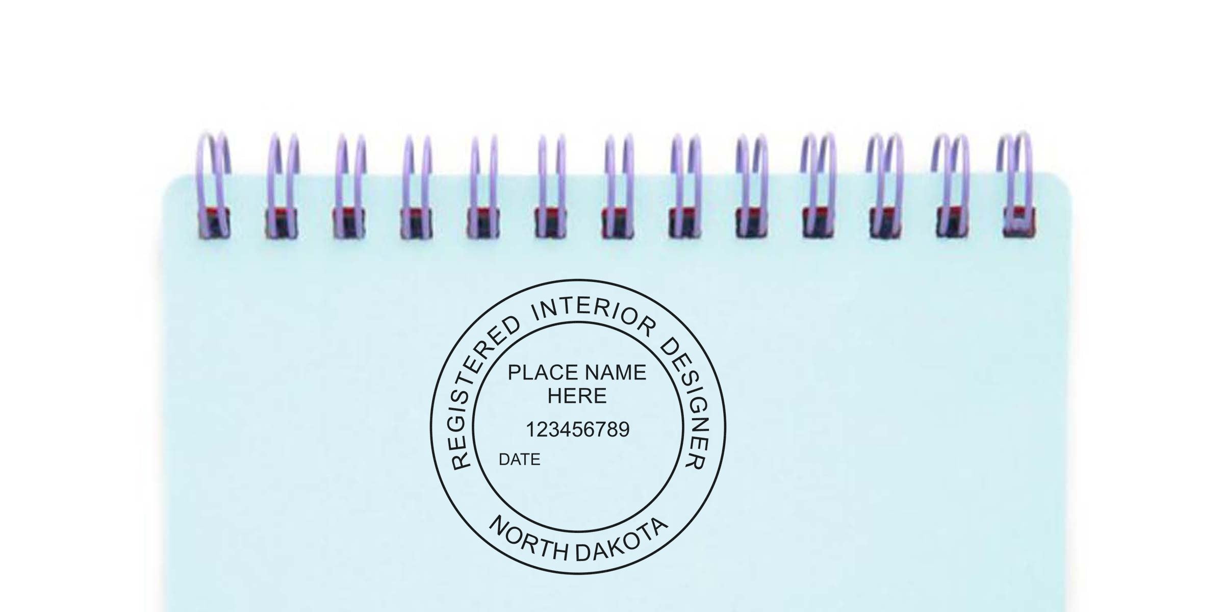 North Dakota interior designer stamp on a spiral notebook page, displaying the registered interior designer seal and application details.