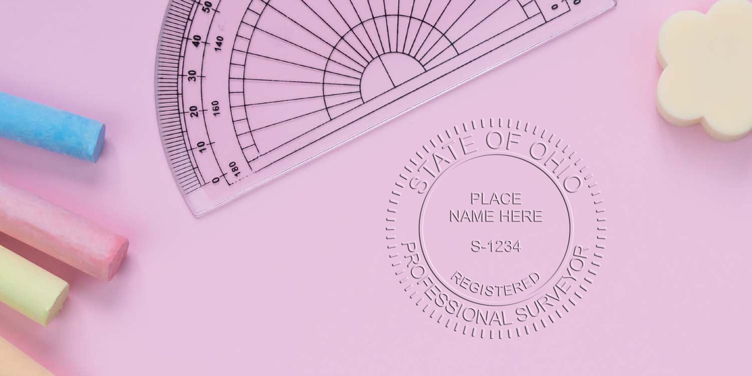 Ohio surveyor stamp on pink background with protractor and colorful chalks, symbolizing the Ohio licensed surveyor certification stamp replacement process.