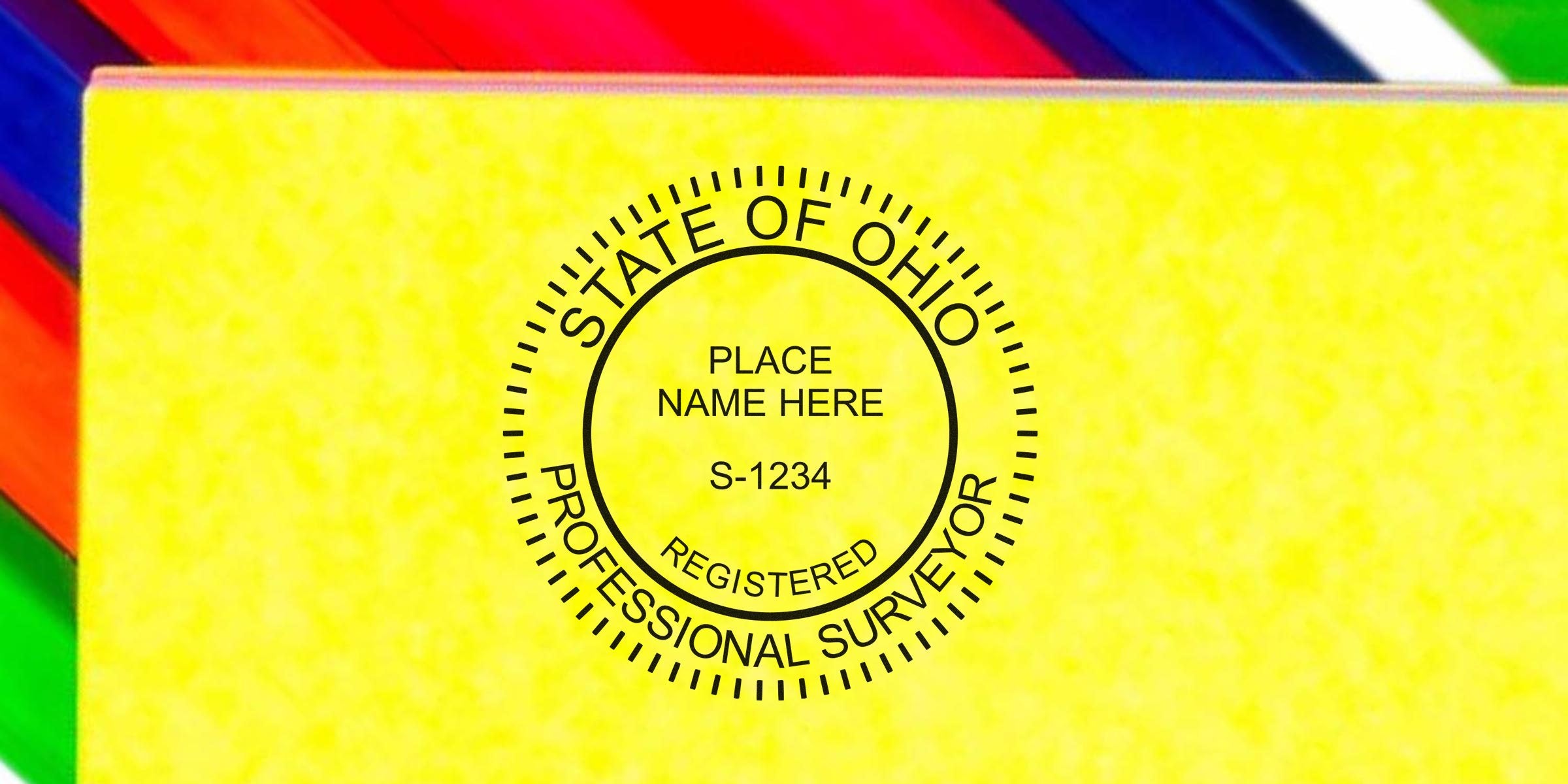 Ohio professional surveyor stamp on a yellow notebook with colorful pencils, showcasing the official Ohio surveyor seal.