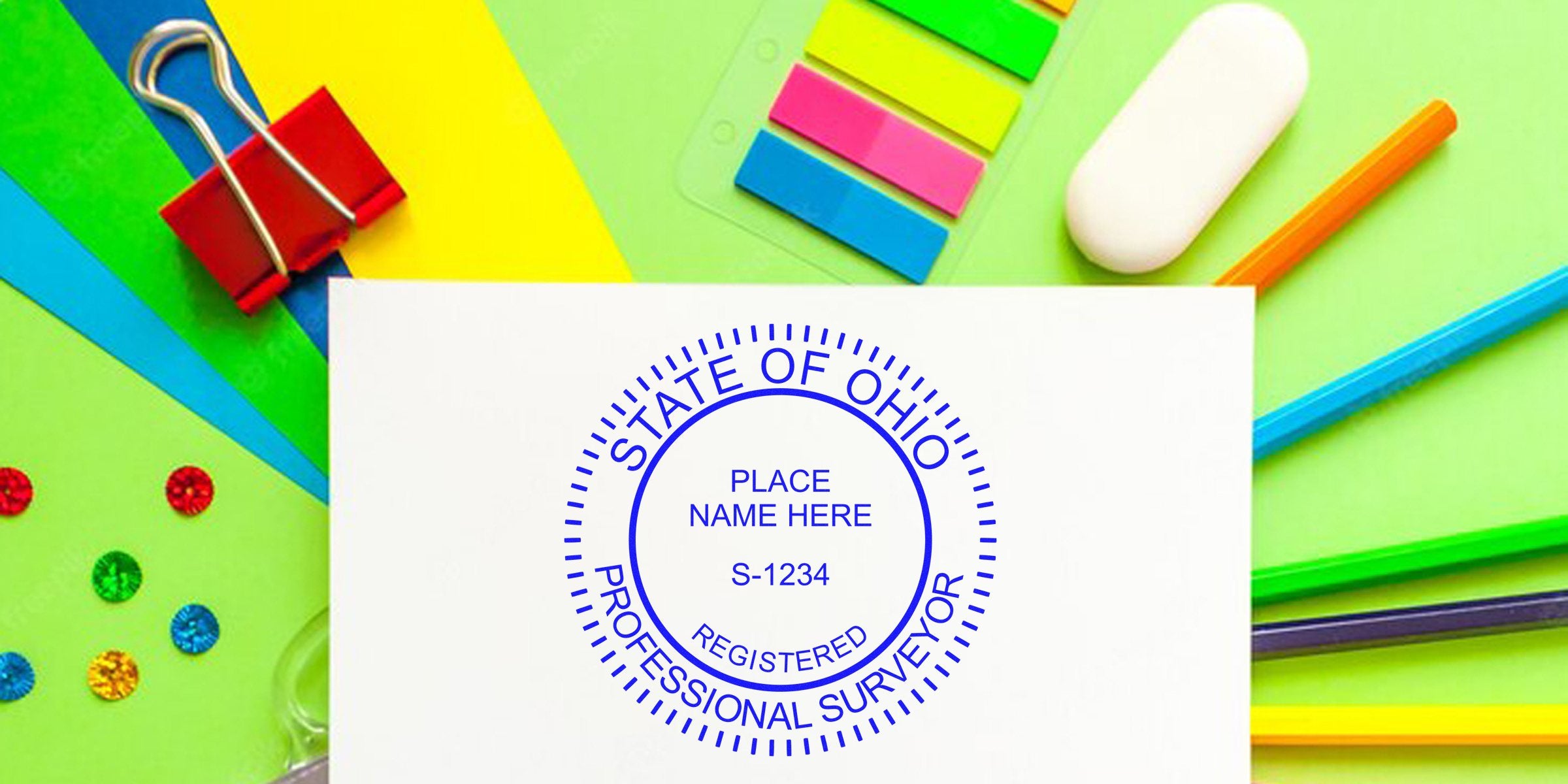 Ohio surveyor stamp on white paper, surrounded by colorful office supplies, emphasizing Ohio surveyor stamp and its requirements.