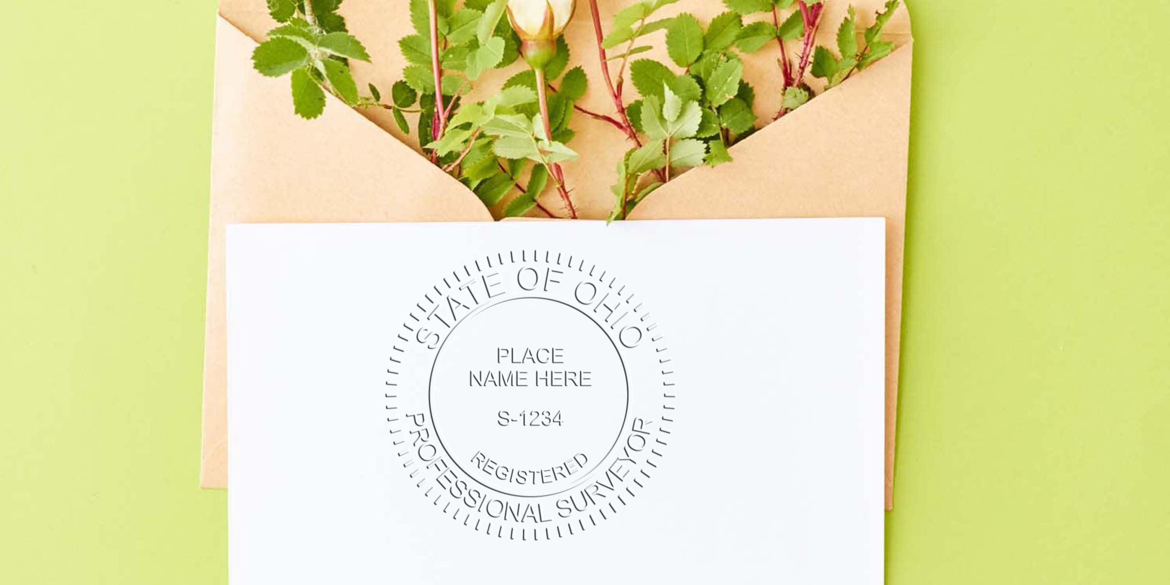 Ohio professional surveyor embossed seal on white paper with envelope and green leaves, featuring Ohio and custom surveyor stamps.