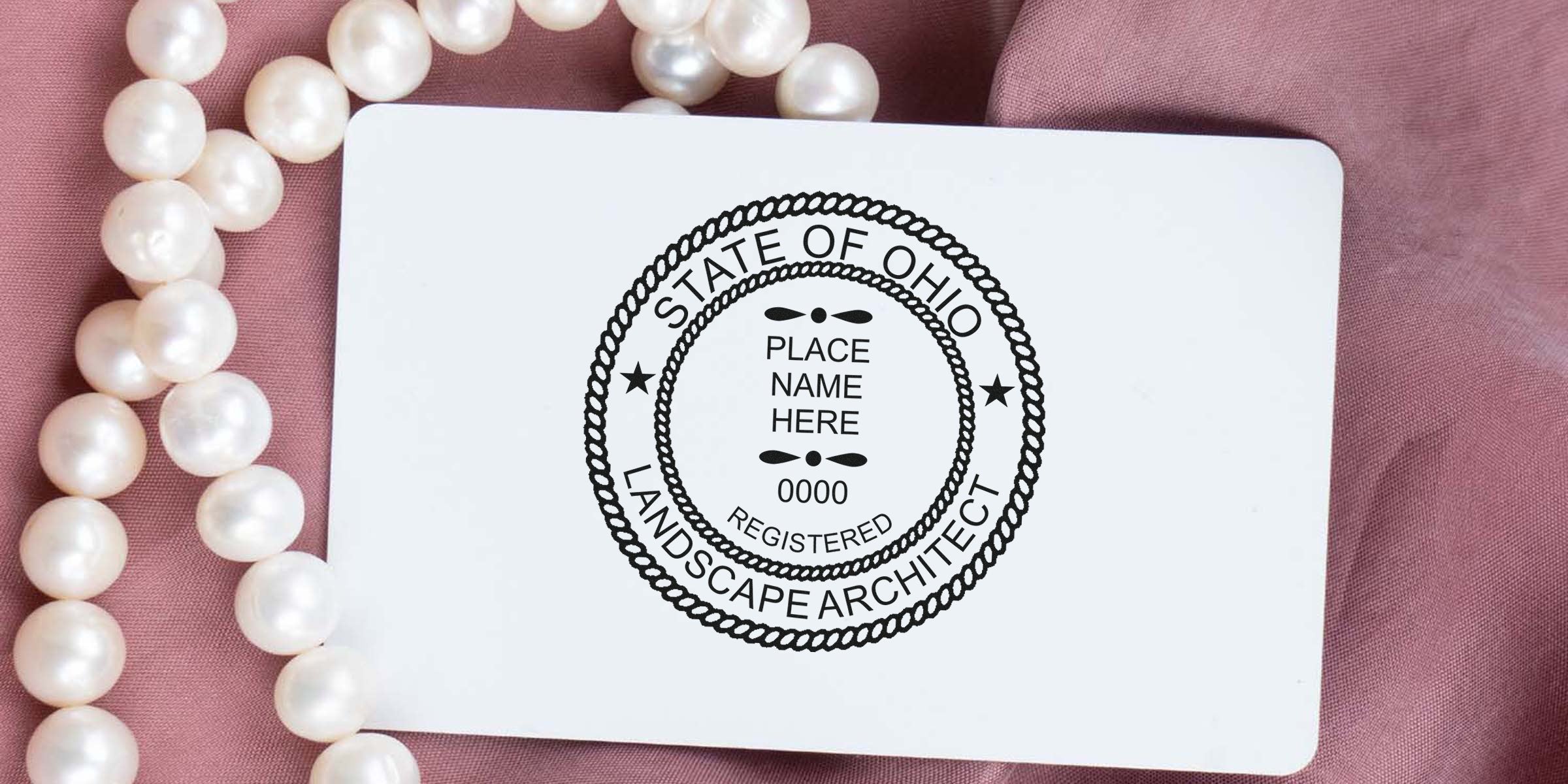 Ohio landscape architect seal on white card with pearl necklace on pink fabric, highlighting Ohio's landscape architect licensing and stamp rules.