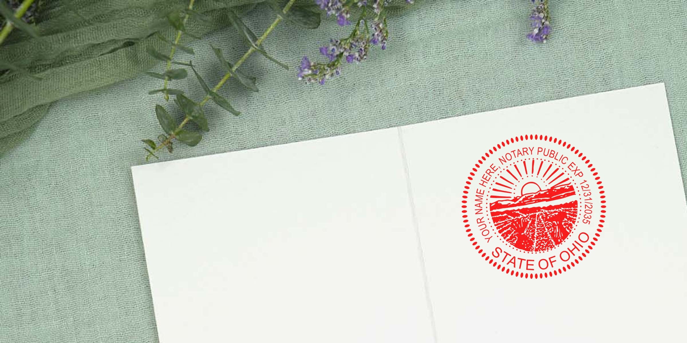 Ohio notary stamp on white paper with official seal, placed on green fabric with purple flowers in the background.