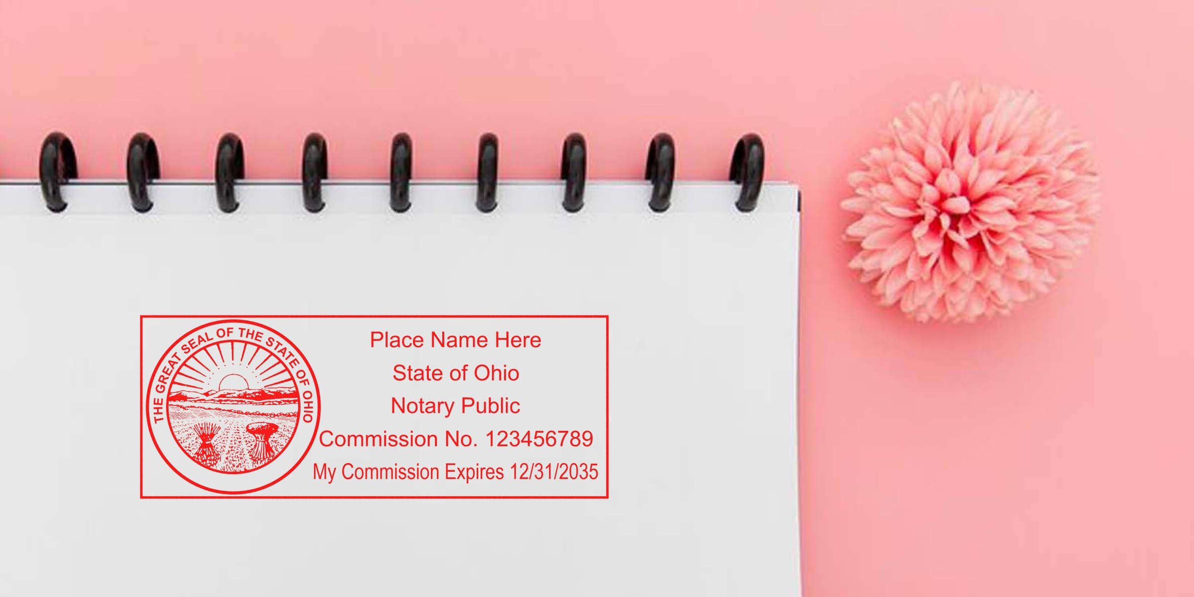 Ohio Notary Public Stamp with commission number and expiration date on a white spiral notebook, pink flower, and pink background, showcasing the Best Notary Stamp Ohio.